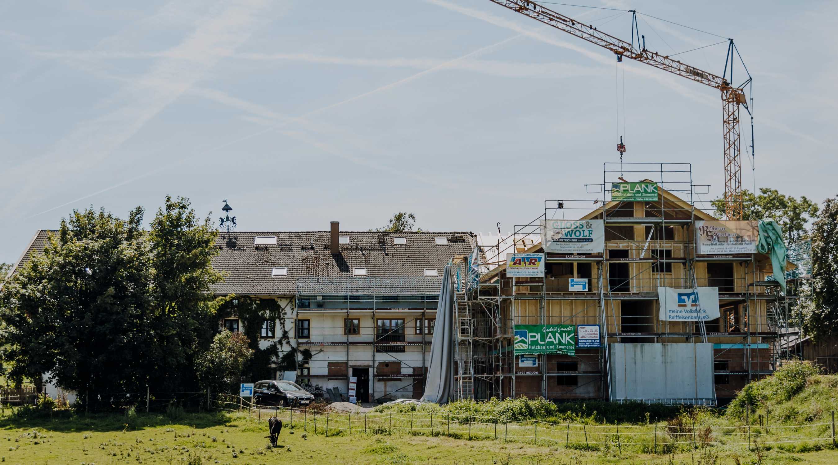 Großes Wohnhaus im Umbau mit Baugerüst und Kran,