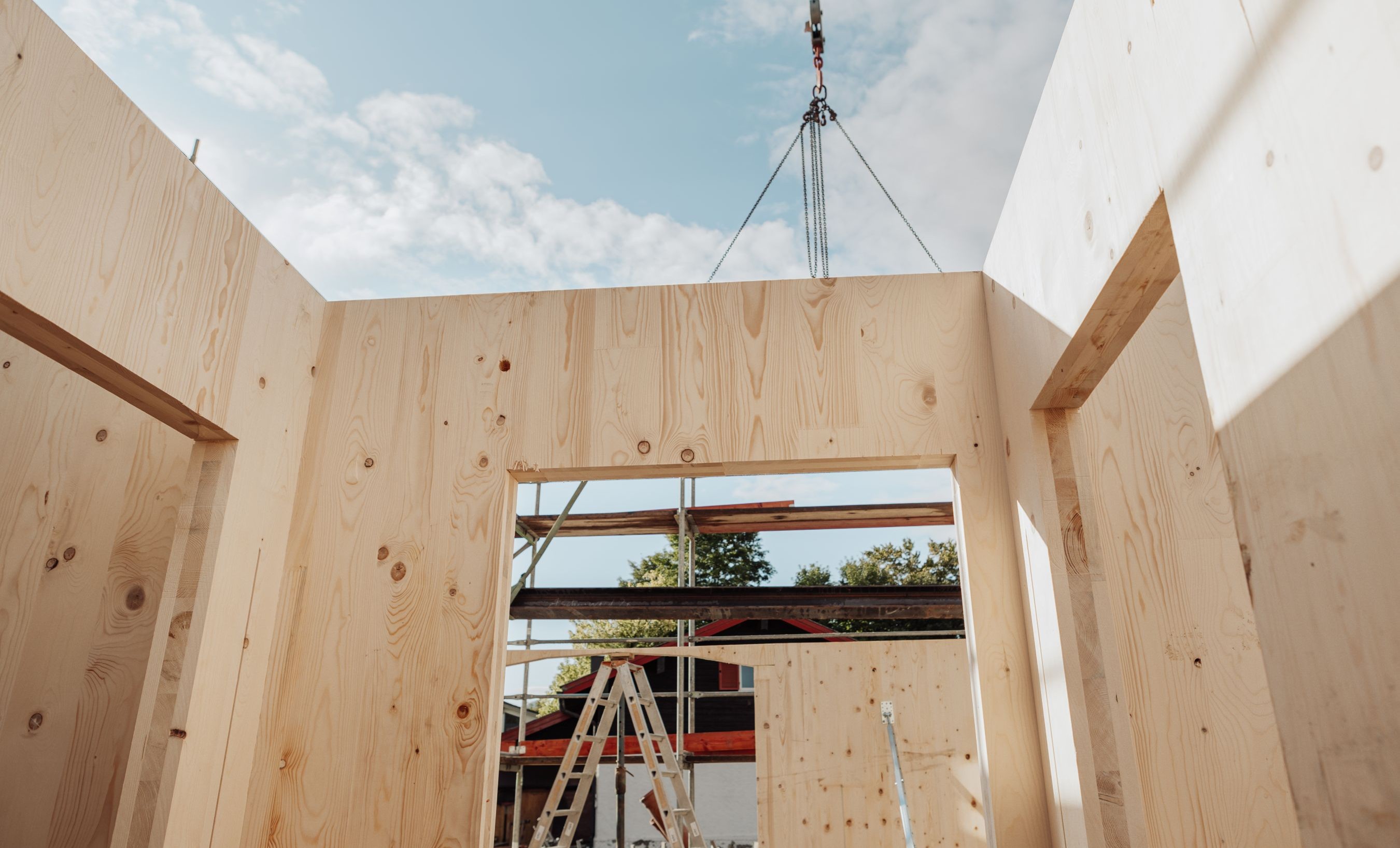 Brettsperrholz-Elemente auf der Baustelle vor Montage, Anbau an Bestandsgebäude in Prutting.