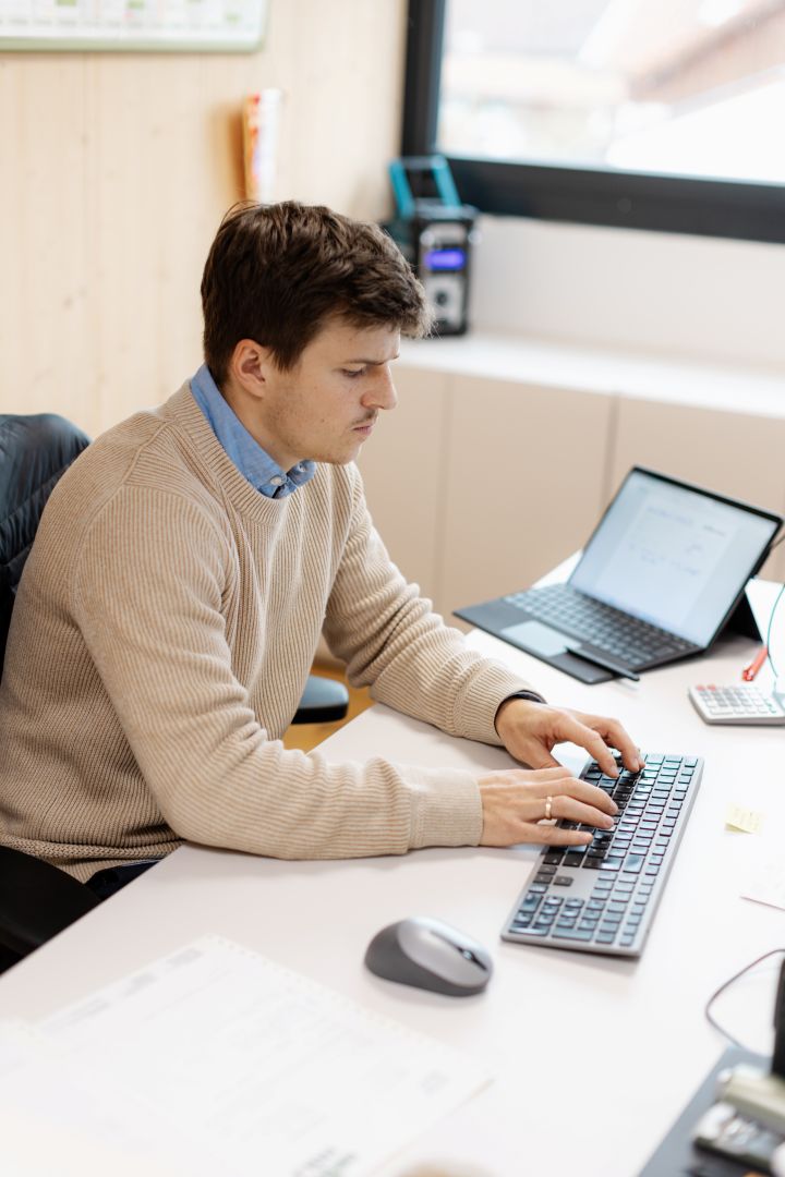 Mann arbeitet im sitzen an einer Tastatur