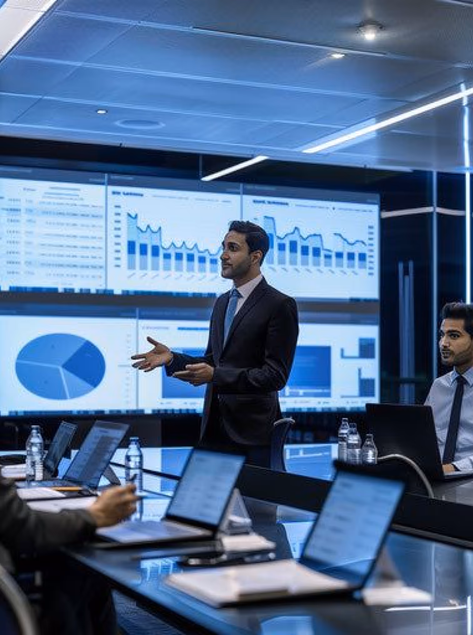 Business meeting with analytics screens in luxurious modern tech tone.