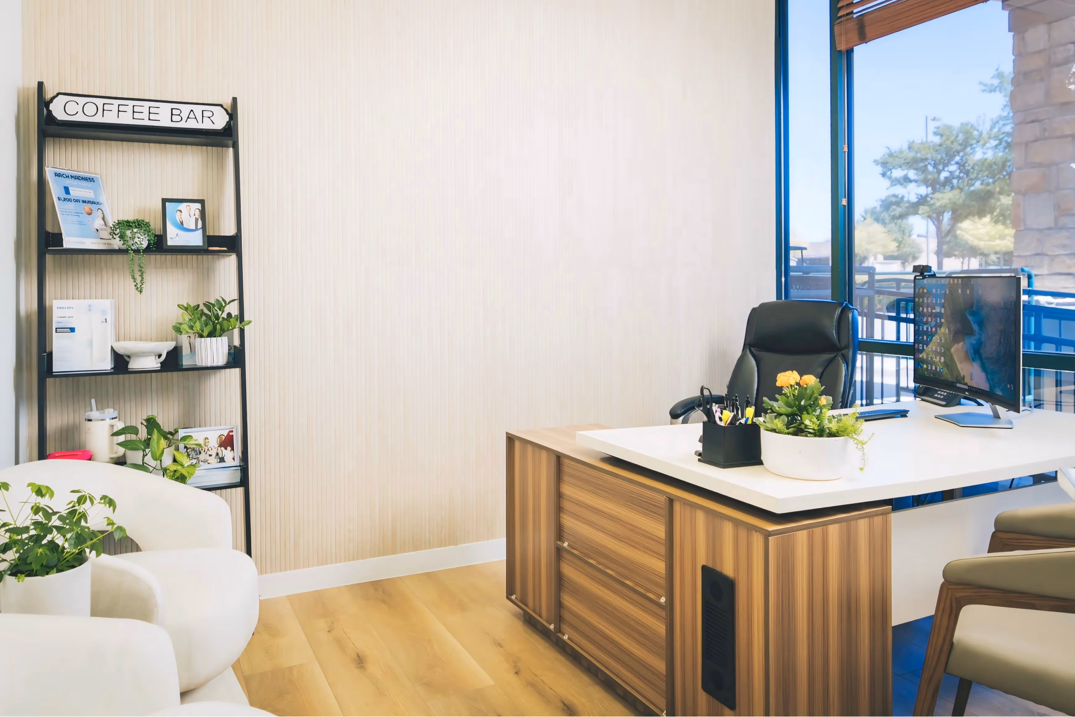 A room with a desk, chairs, and a window.