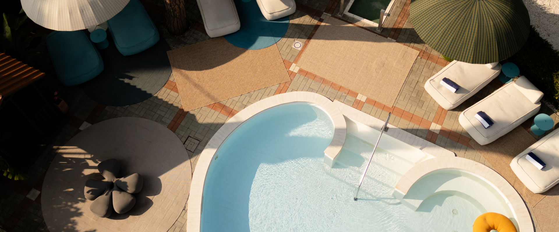 Aerial view of pool with colorful umbrellas and lounge chairs at La Serena.