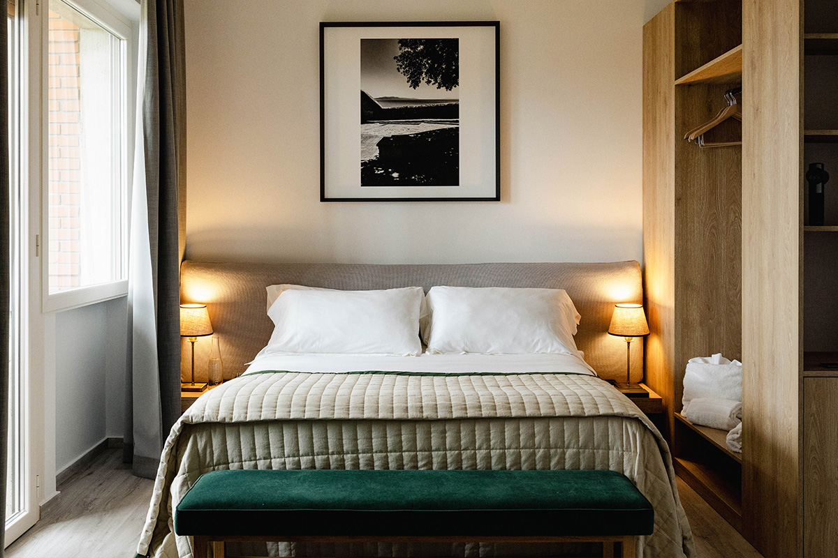 Elegant hotel room featuring a double bed, soft lighting, and a cozy ambiance.