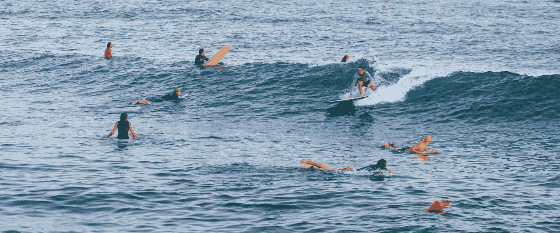 People surfing and paddling in the sea during a calm day