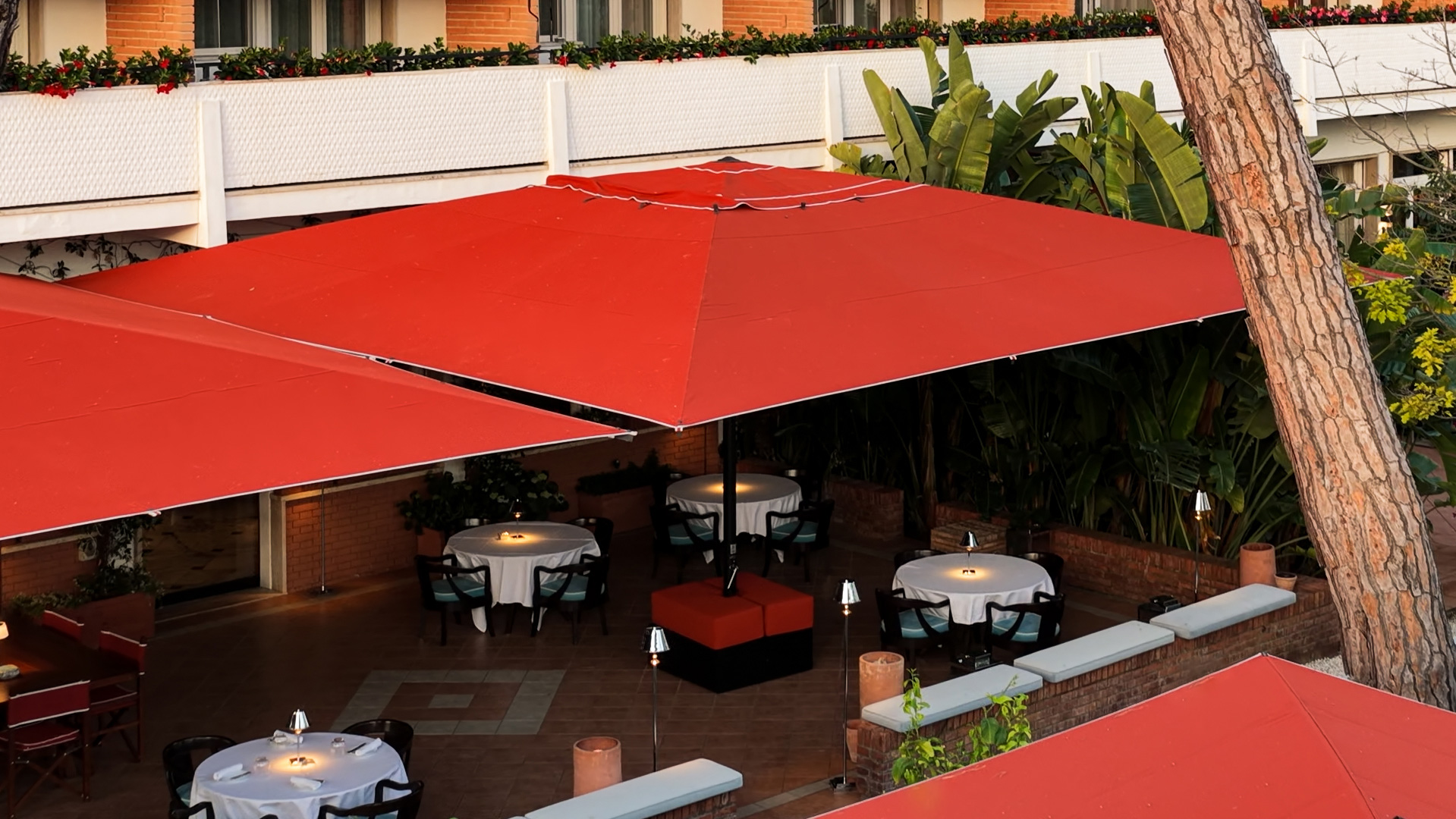 Relaxing meal on a terrace with warm lighting and lush surroundings.