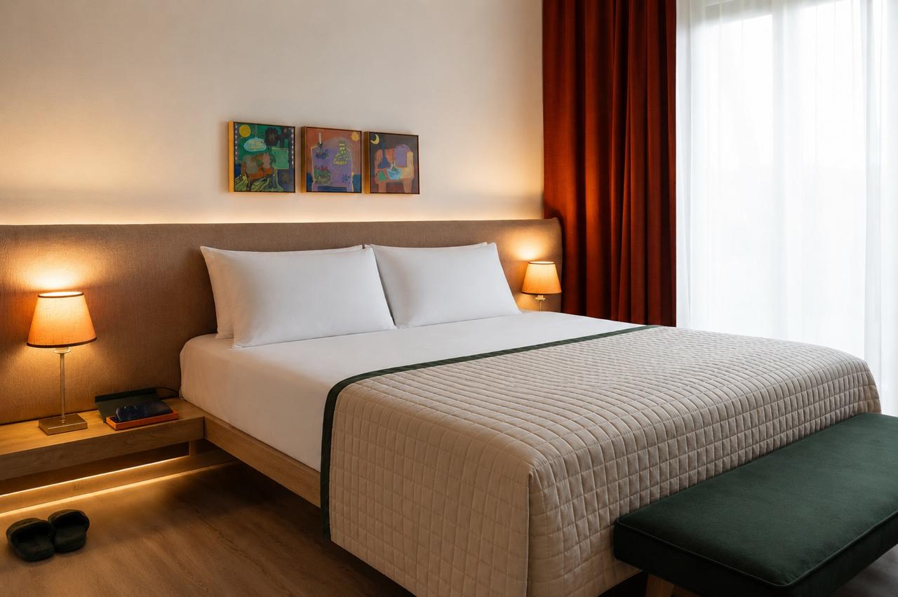 Elegant deluxe room with a private balcony offering a scenic view of the gardens.
