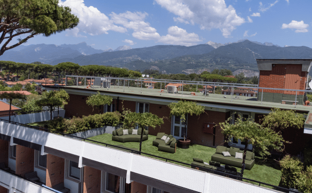 Vista laterale del Serena Hotel circondato da una vegetazione rigogliosa sotto un cielo azzurro terso.