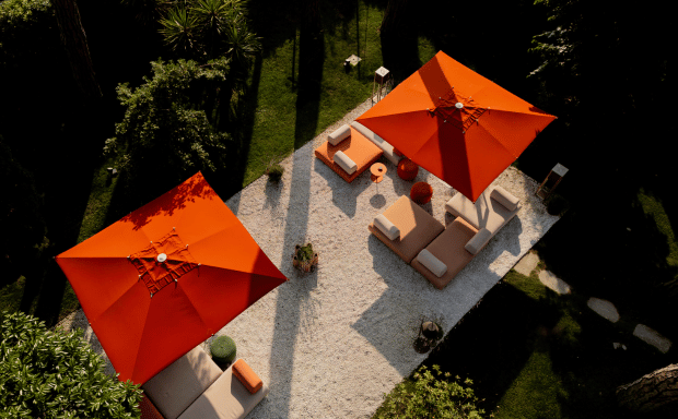 Terrazza dell'hotel con ombrelloni arancioni e ampi spazi verdi circostanti