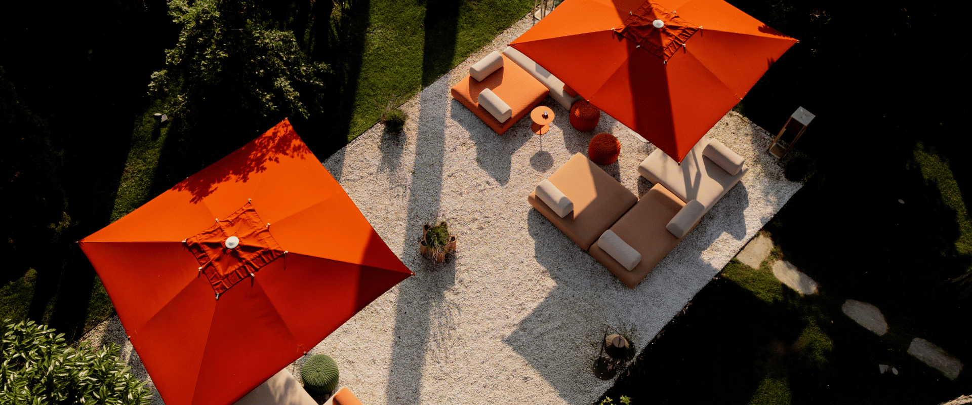 Spaziosa terrazza all'aperto con ombrelloni arancioni e vegetazione tropicale