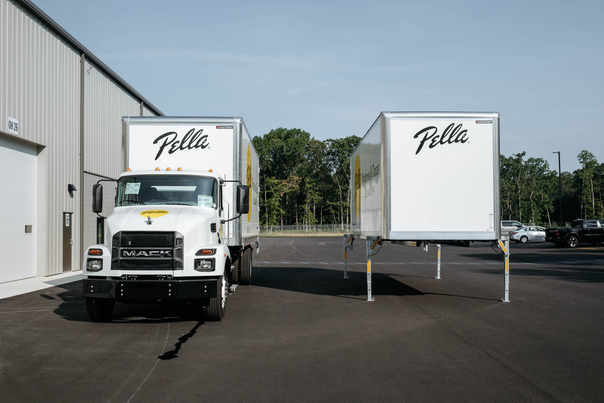 Mack truck parked beside a freestanding Victory demountable truck body positioned at a loading dock, ready for swap-in.