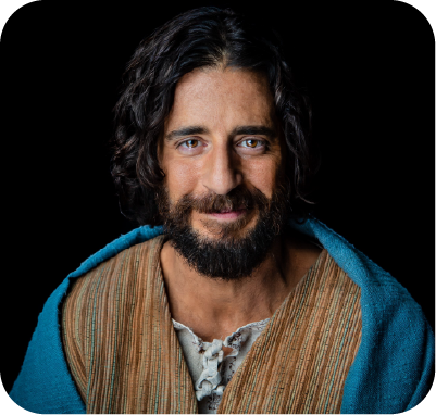 Two men smiling on stage with colorful floral jackets, one holding a microphone.