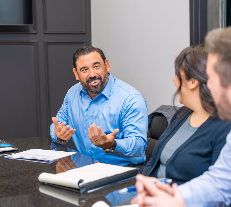 An Ironpeak regional manager holds a meeting with the staff of a Member Agency in a large conference room.