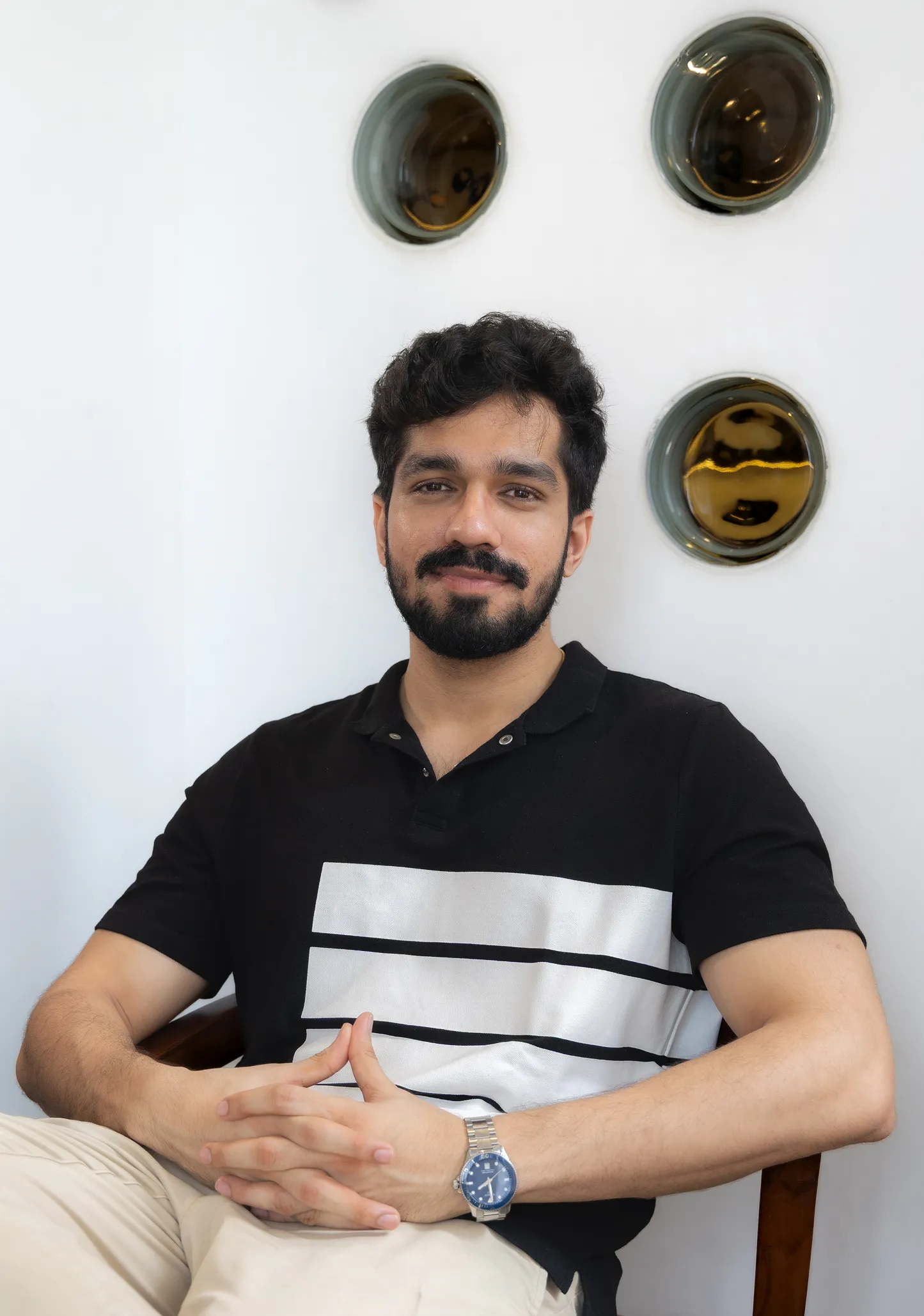 Portrait photo of Rishabh Jain, Founder of Confetti, smiling and sitting down.
