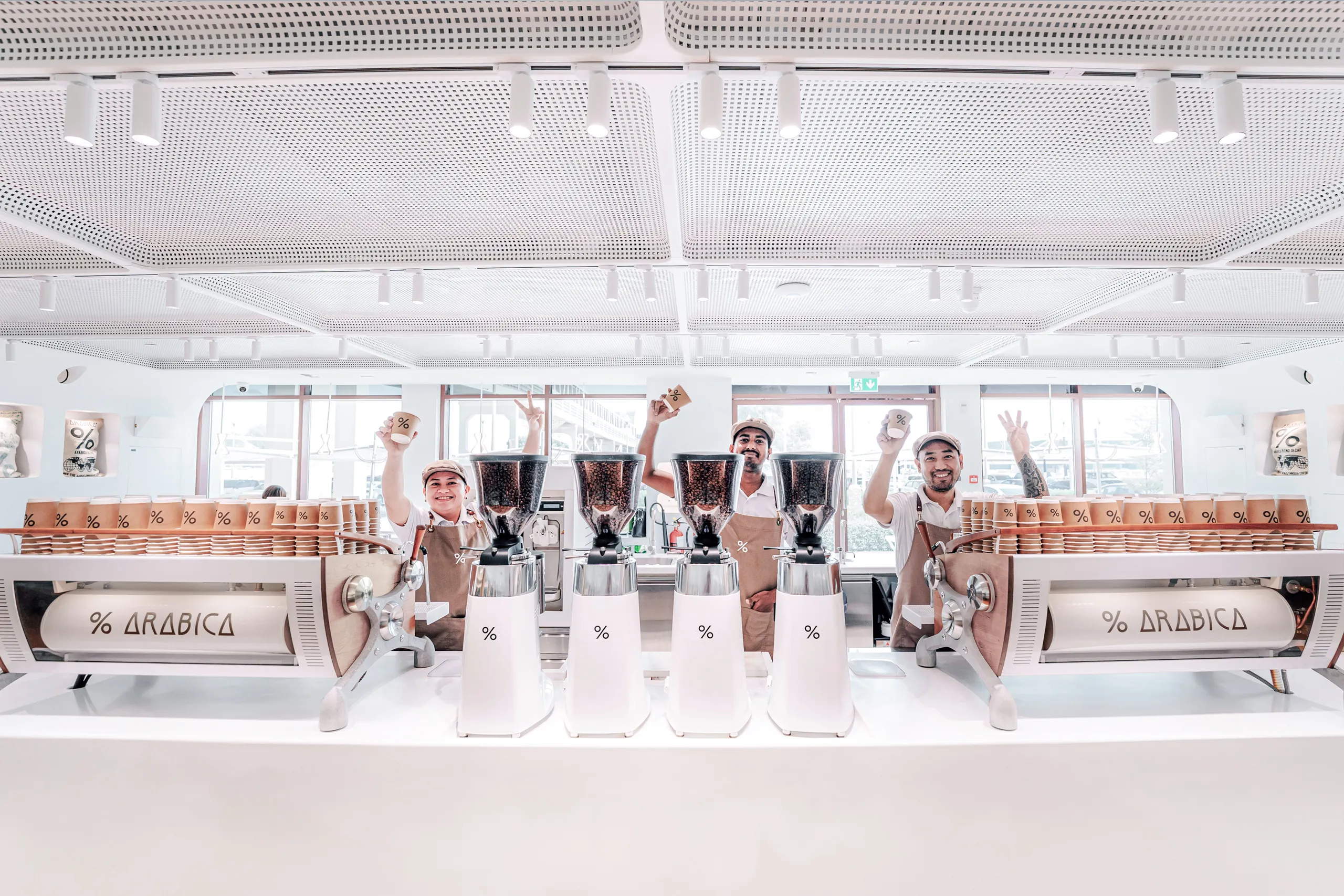 % Arabica specialty coffee shop interior featuring white minimalist design and custom espresso machines Dubai