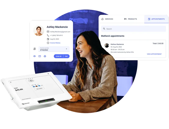 Smiling woman sitting at a table using a payment terminal, with digital overlays showing client details and appointment information for Ashley Mackenzie and Mathew Mackenzie.