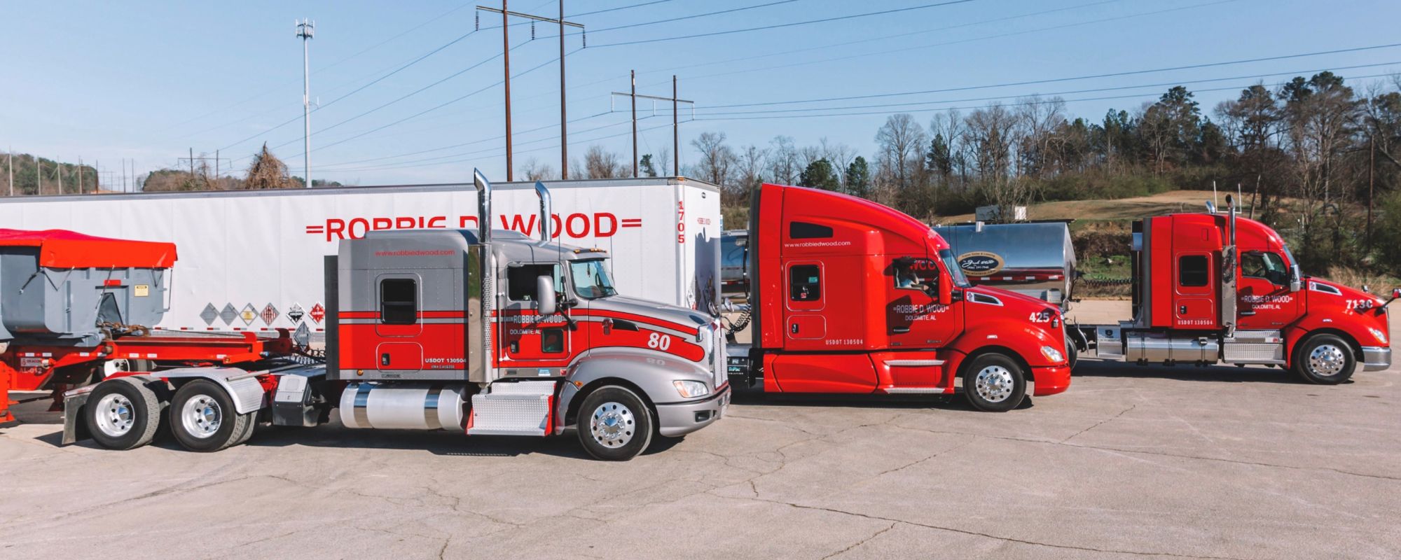 Red Robbie D. Wood semi-trucks parked in a lot