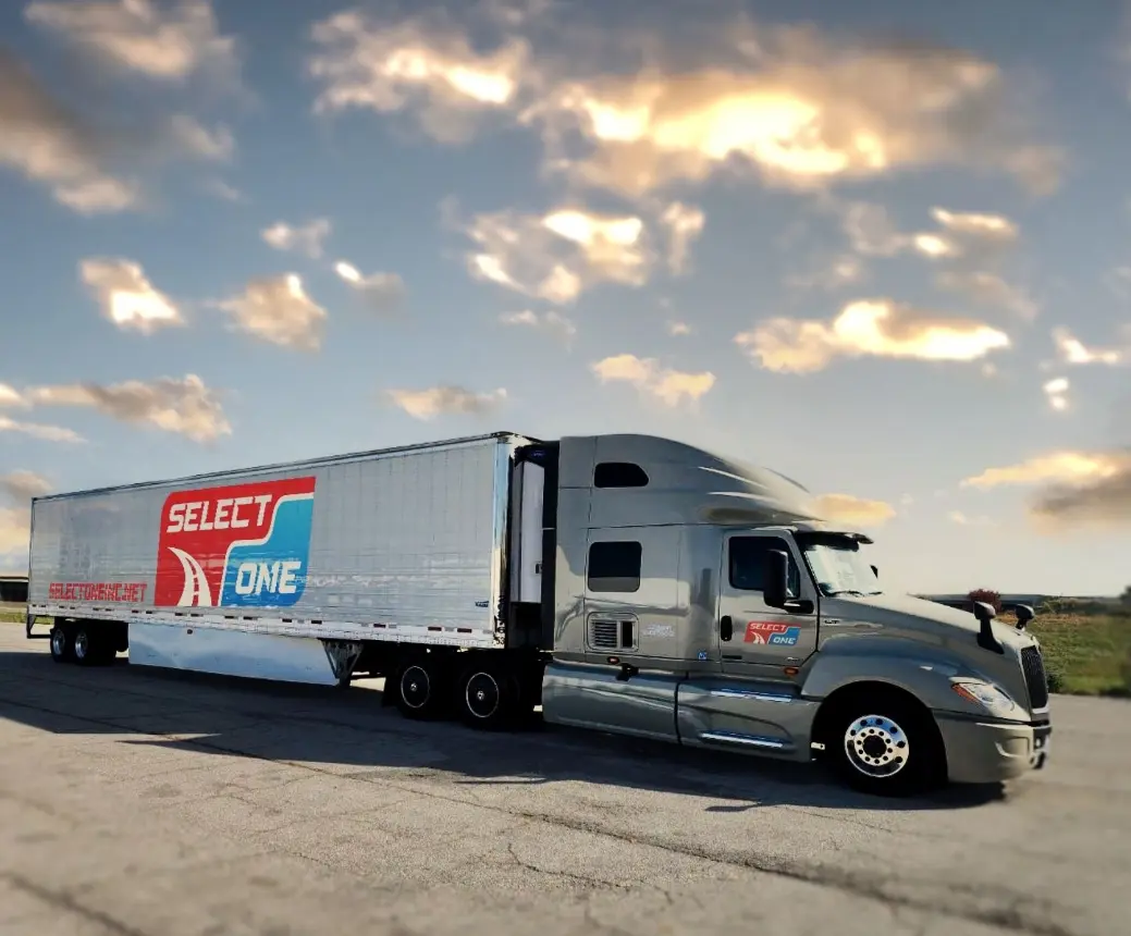 Gray Select One semi-truck with trailer at sunset