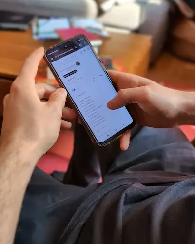 Un homme Tenant un smartphone et lisant un texte sur Pochade la plateforme d'écriture.