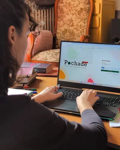 Femme vue de dos navigant sur Pochade la plateforme d'écriture depuis son ordinateur portable. 