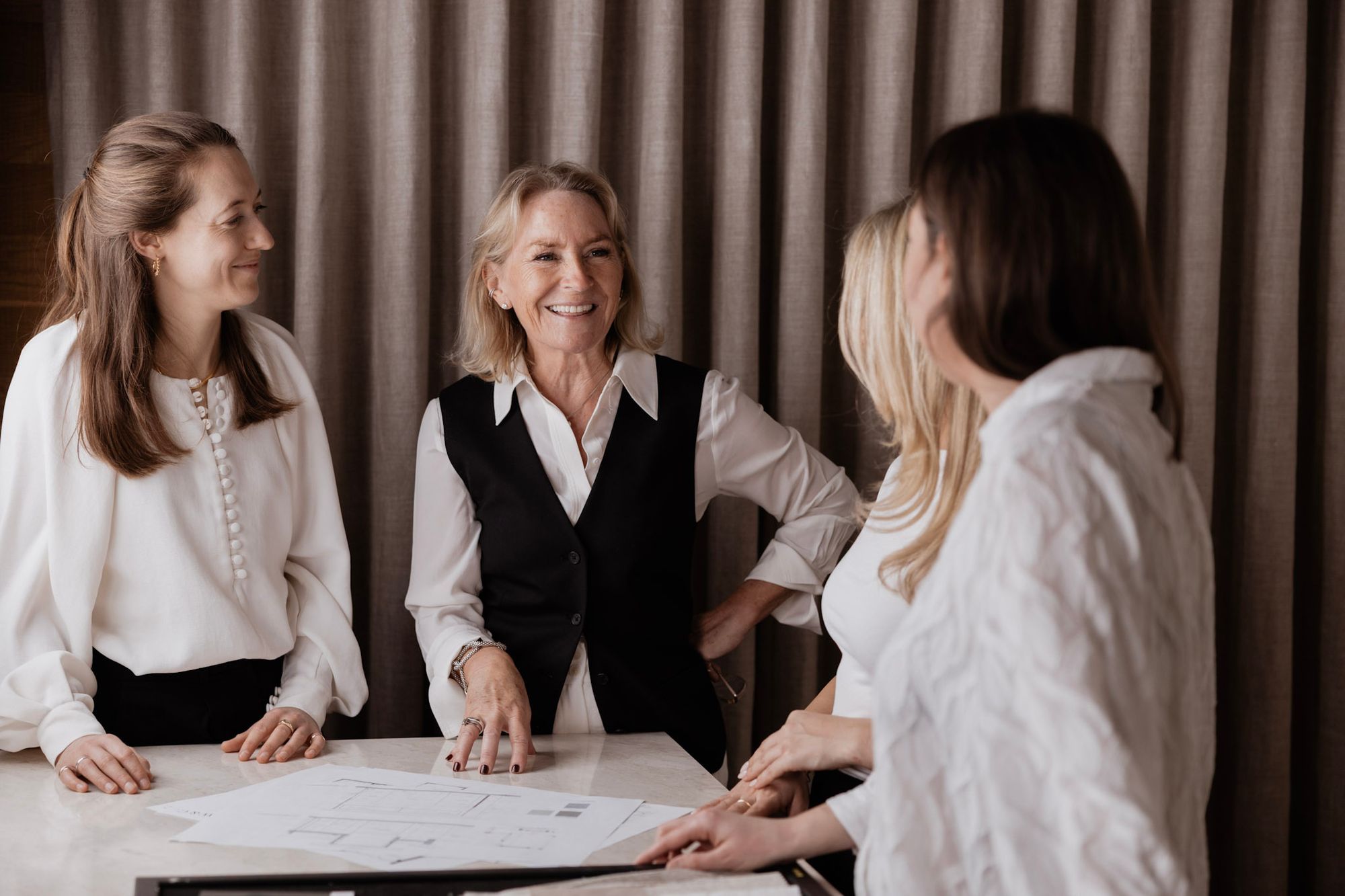 Inside of a living room with 3 couches around a table