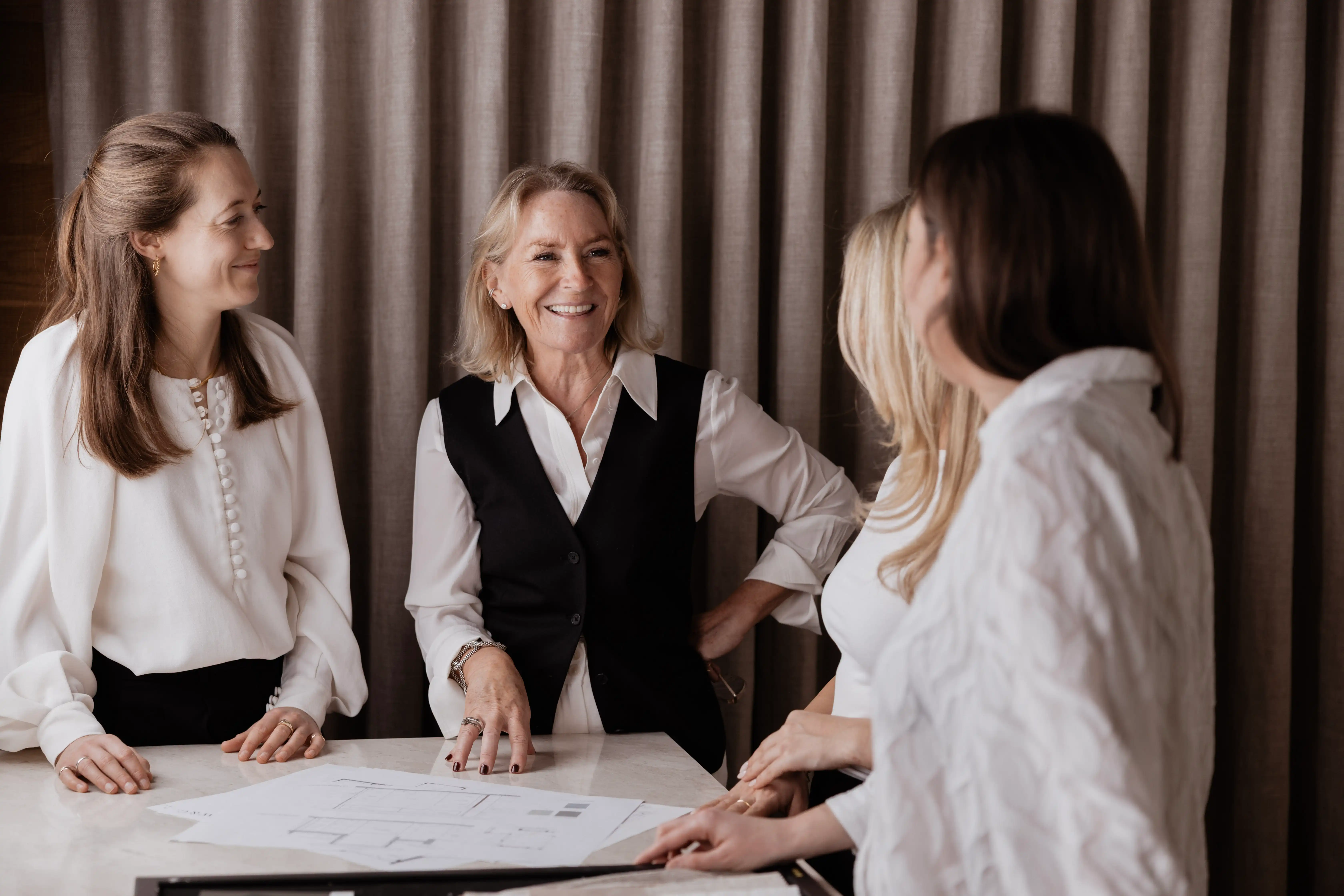 Inside of a living room with 3 couches around a table