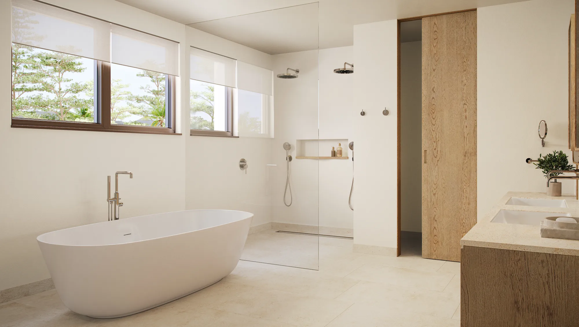 Freestanding oval soaking tub and glass-walled walk-in shower in a light-filled primary bathroom with double vanity at Four Seasons Nevis Peak Residences