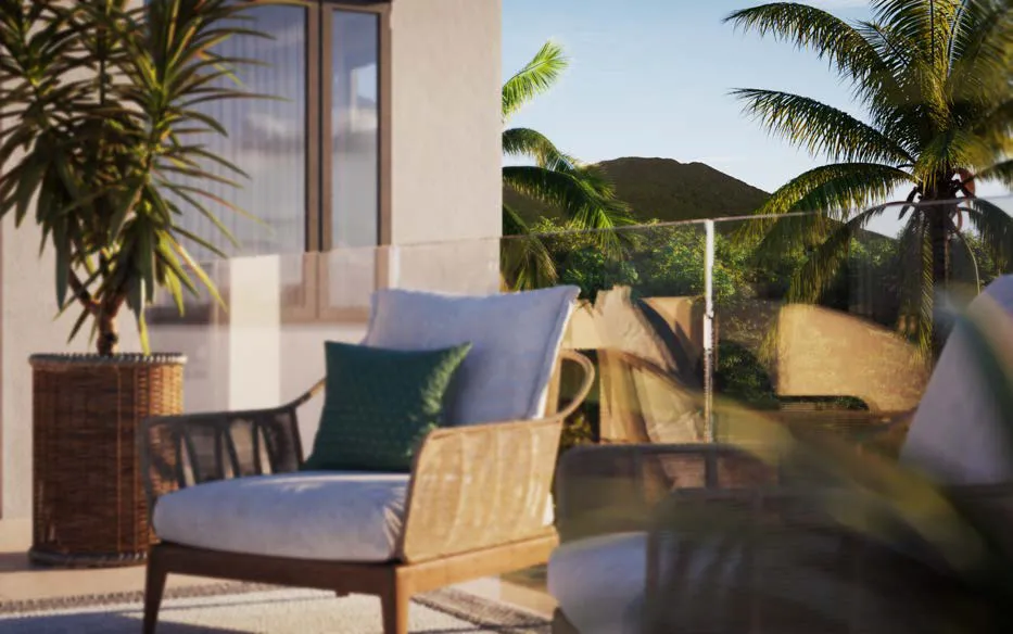 Outdoor lounge seating on a terrace framed by palm trees with views of Nevis Peak at Four Seasons Nevis Peak Residences