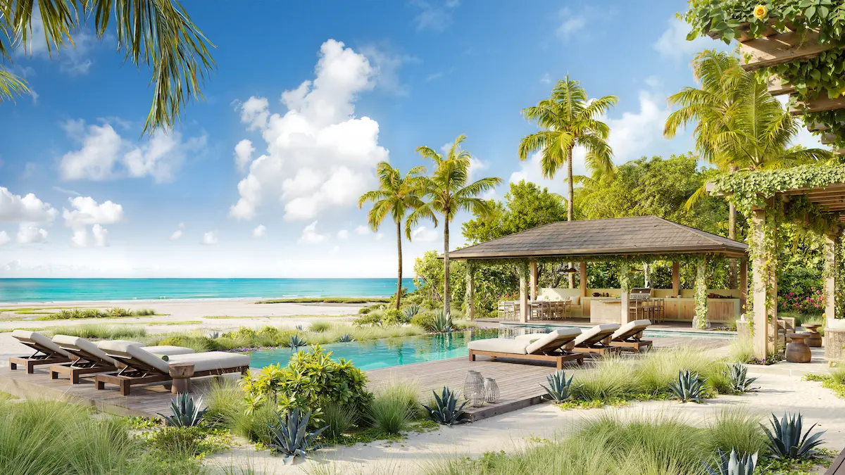 Beachfront pool and covered outdoor dining pergola surrounded by palm trees at Nobu Residence, Barbuda