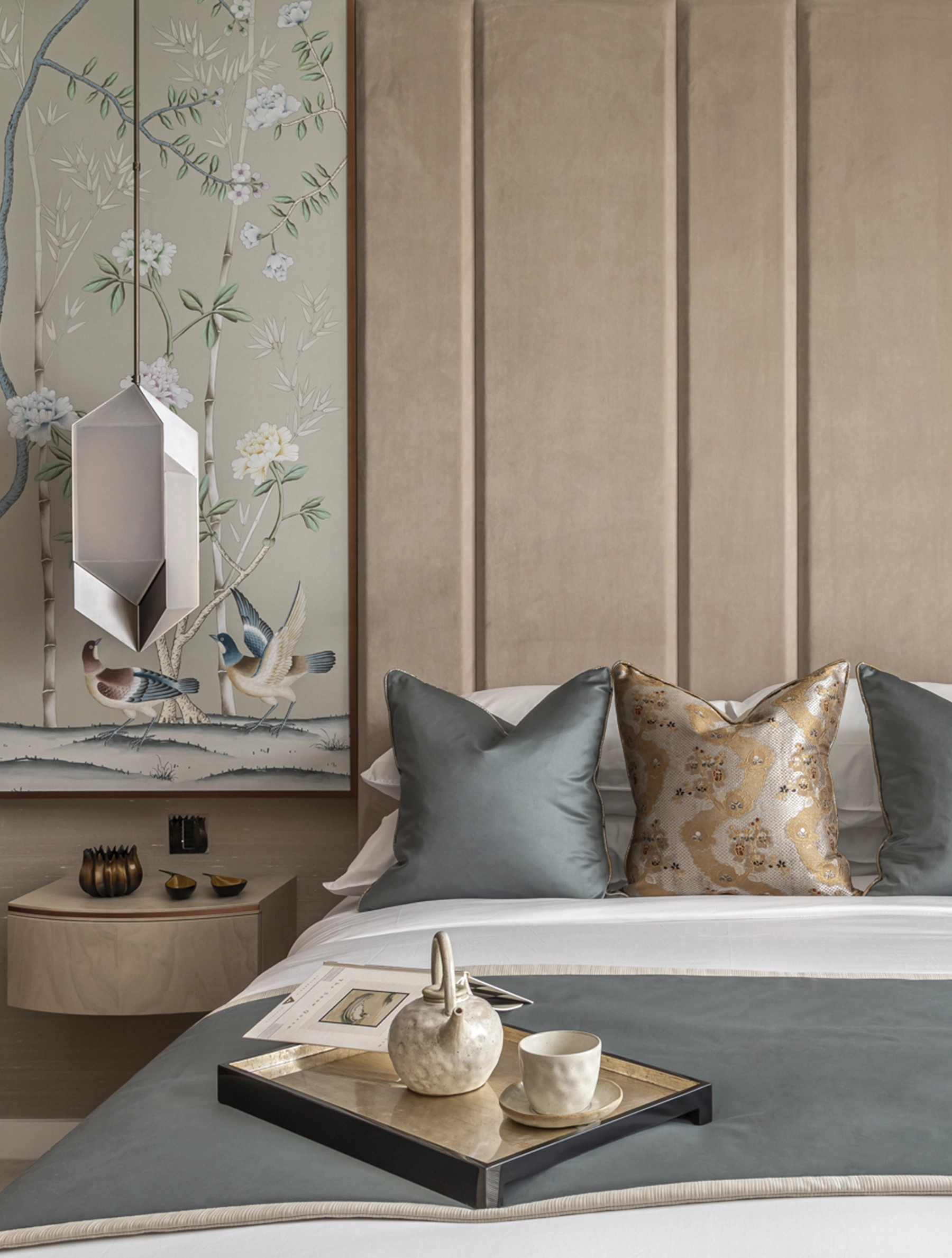 Bedroom with a panelled upholstered headboard, hand-painted chinoiserie bird panel and teal and gold silk cushions at Willow, London