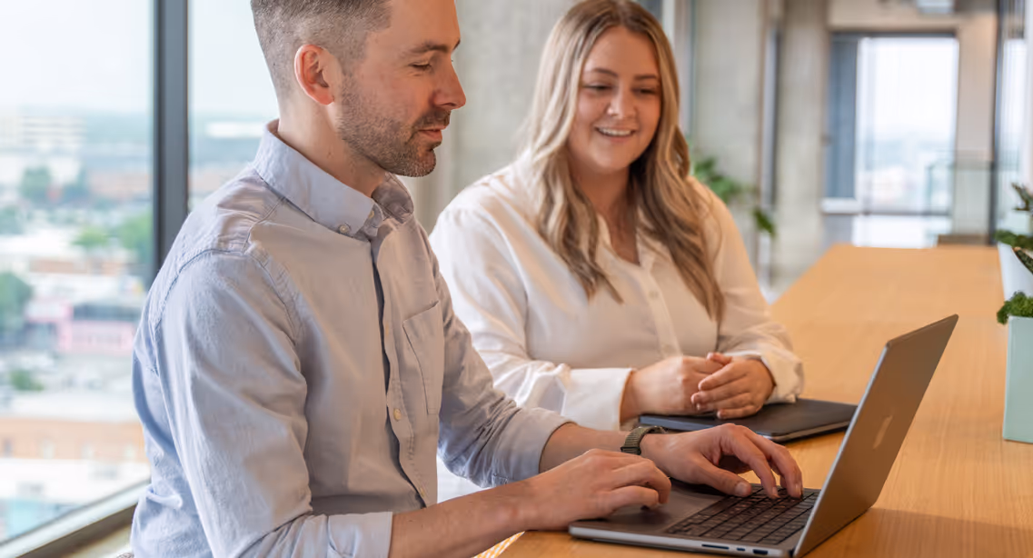 2 people sitting in front of a laptop