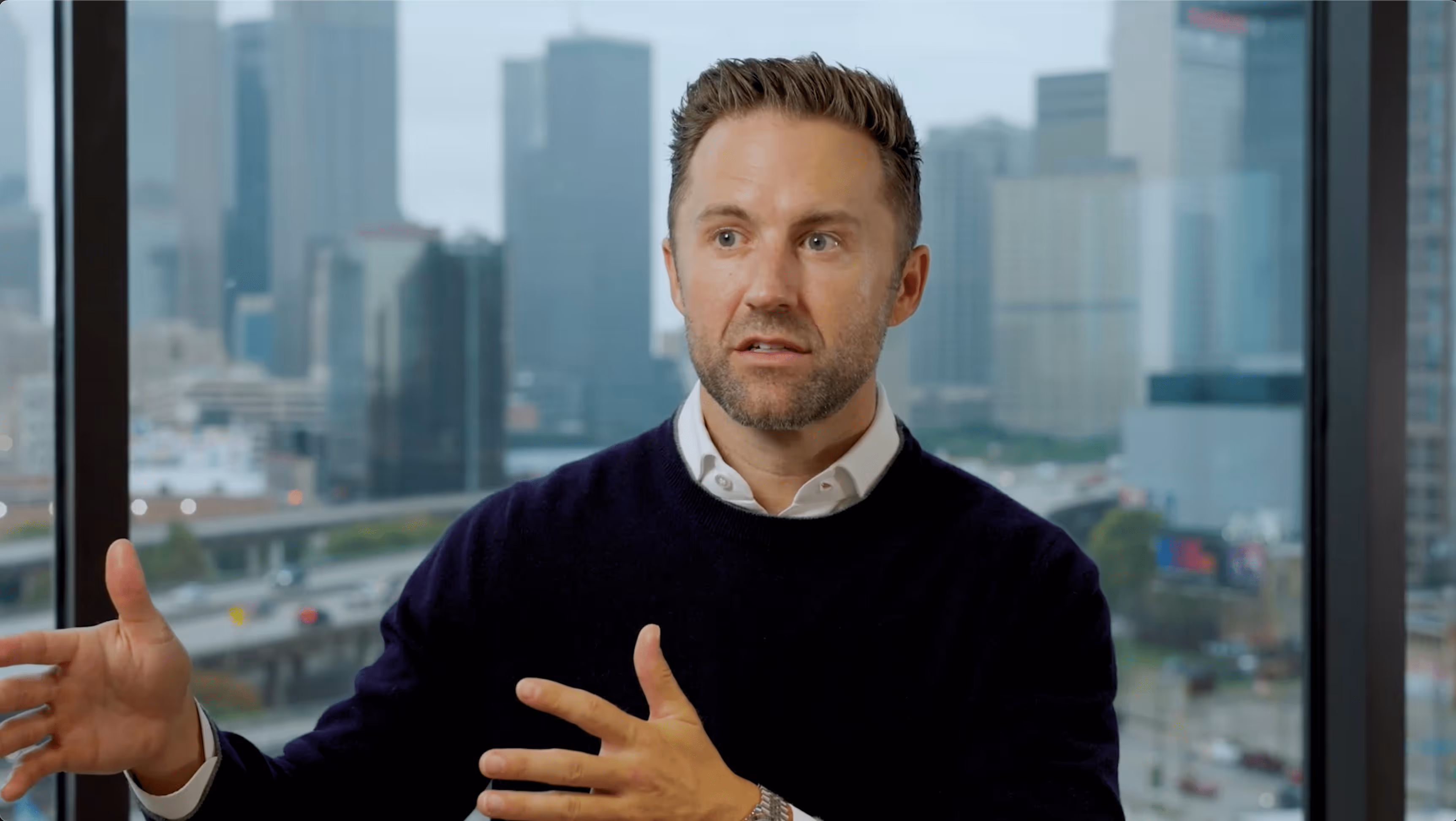 a man sitting in an office in front of a skyline
