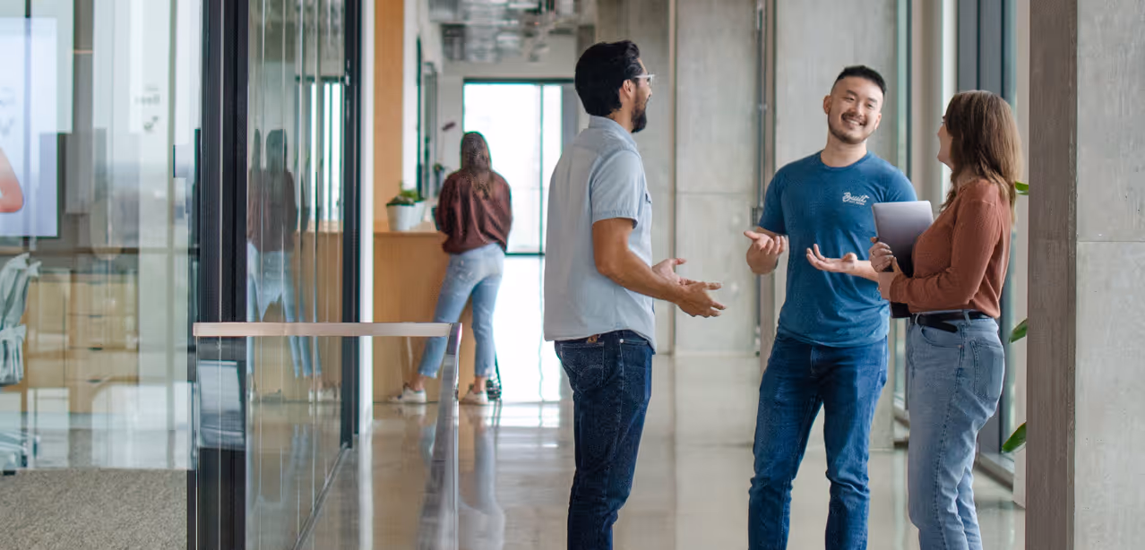 Employees in Dallas, TX office conversing.