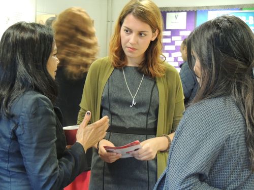 A caucasian woman listening intently to an asian woman in a community environment setting,