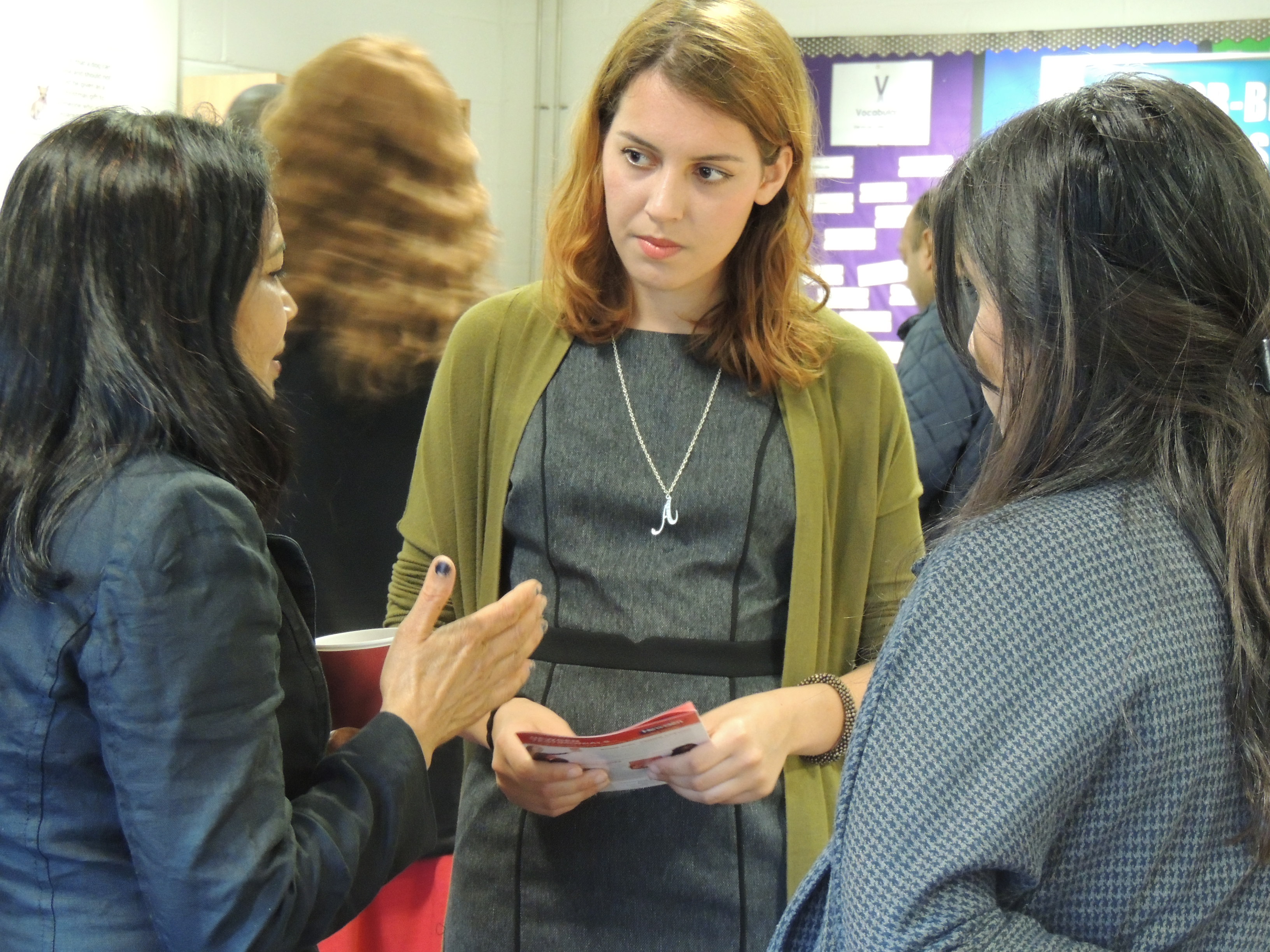 A caucasian woman listening intently to an asian woman in a community environment setting,