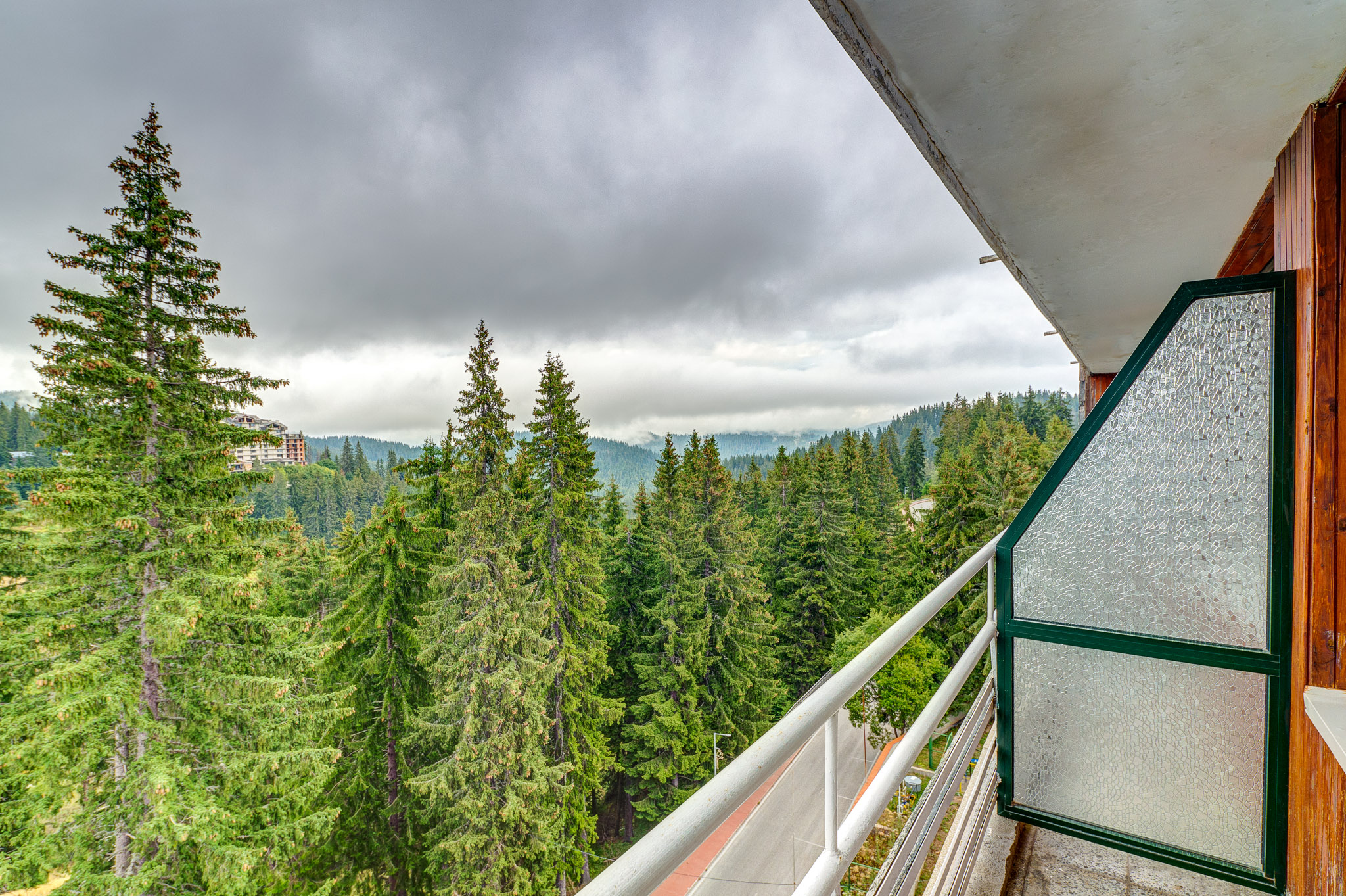 Удобен кът за сядане в двойна стая Standard в Гранд Хотел Мургавец, включващ бежов фотьойл, нощно шкафче и елегантни завеси за релаксираща атмосфера.