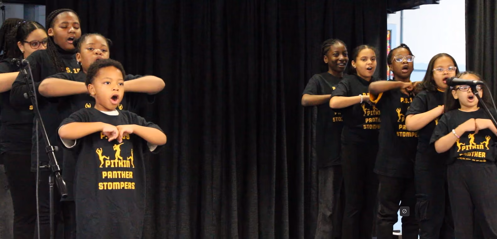 Student leading group stomp performance at mic.