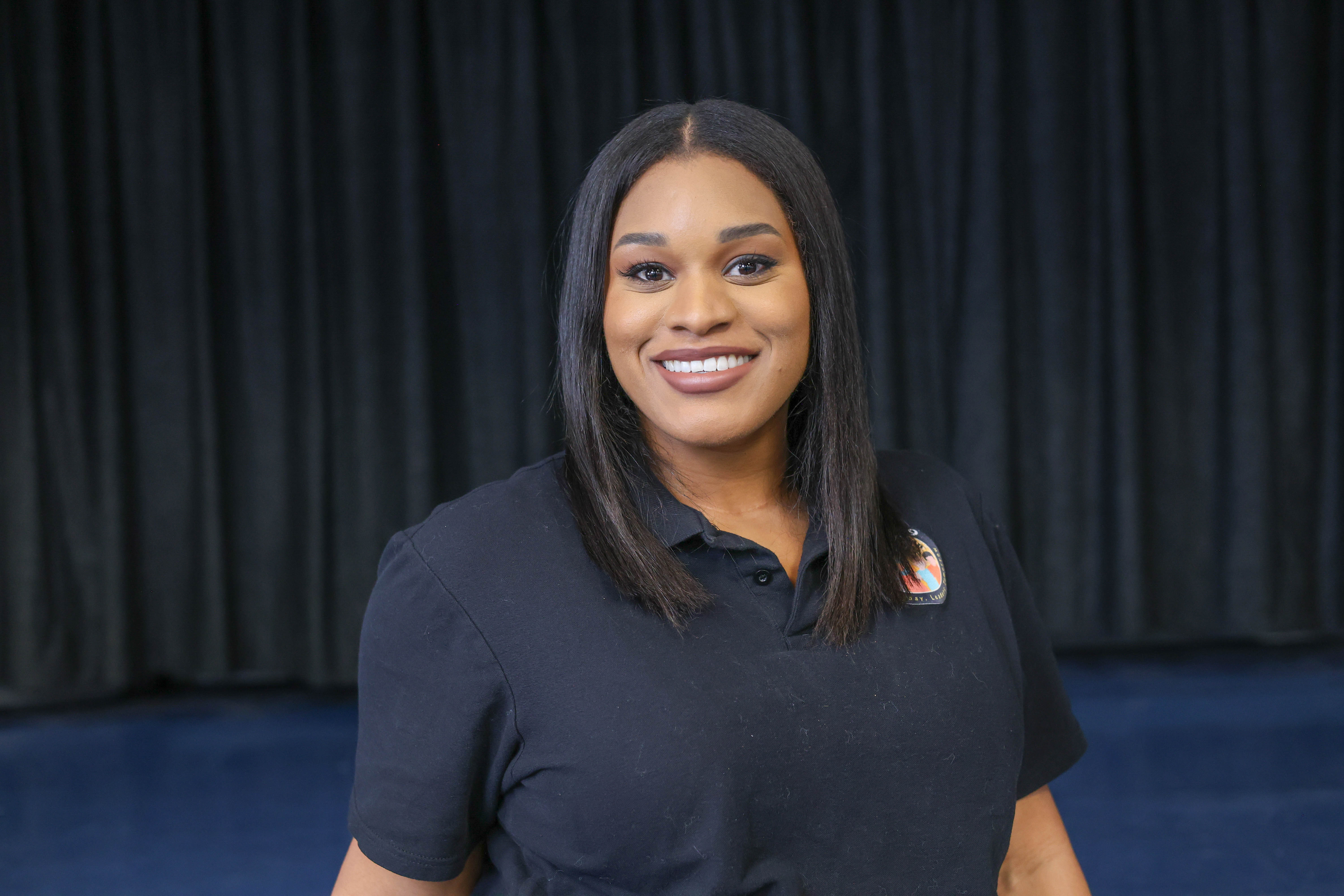 Rolonda Osborne smiling in black school staff polo shirt