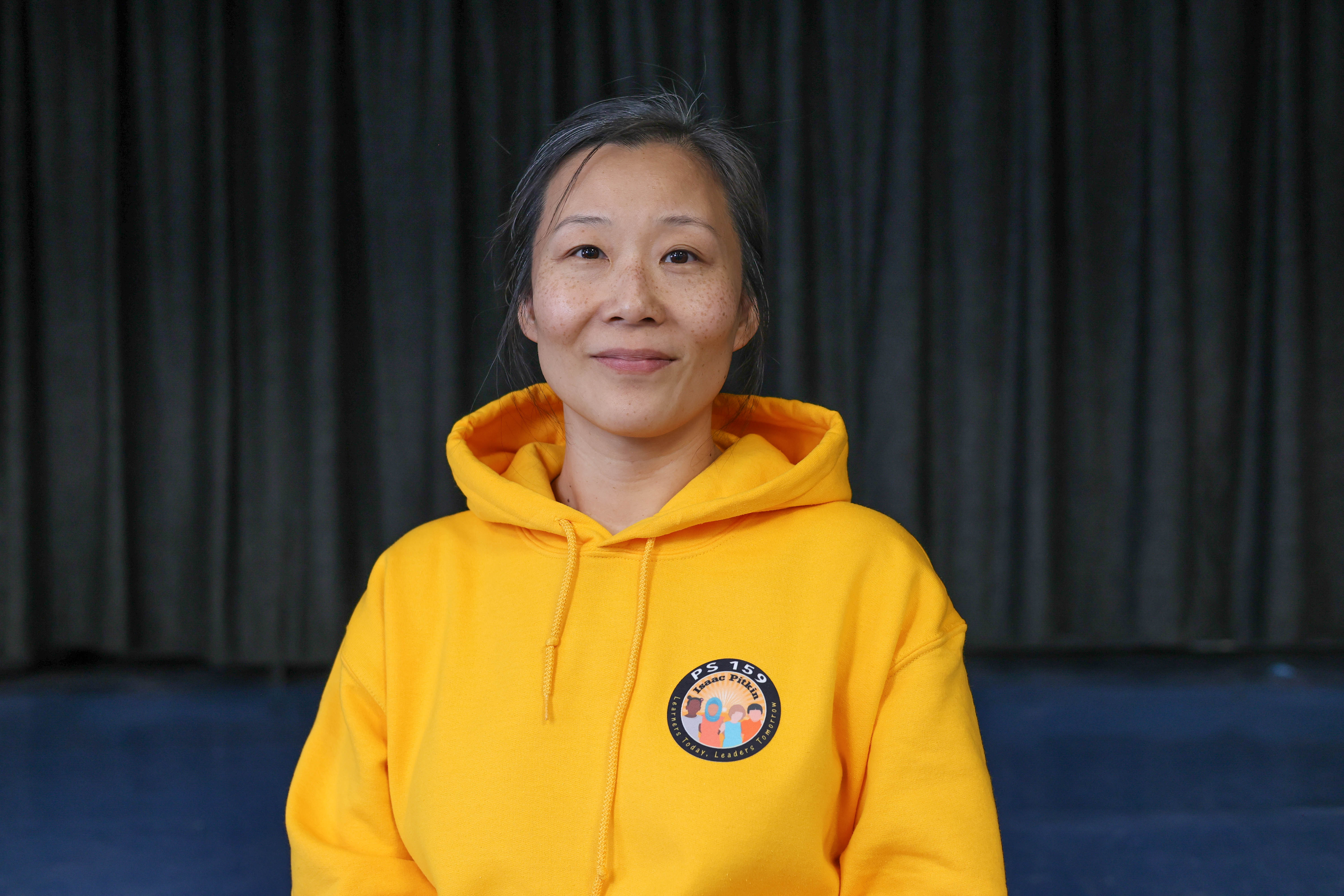 Emily Oh PS 159 staff member in yellow school hoodie