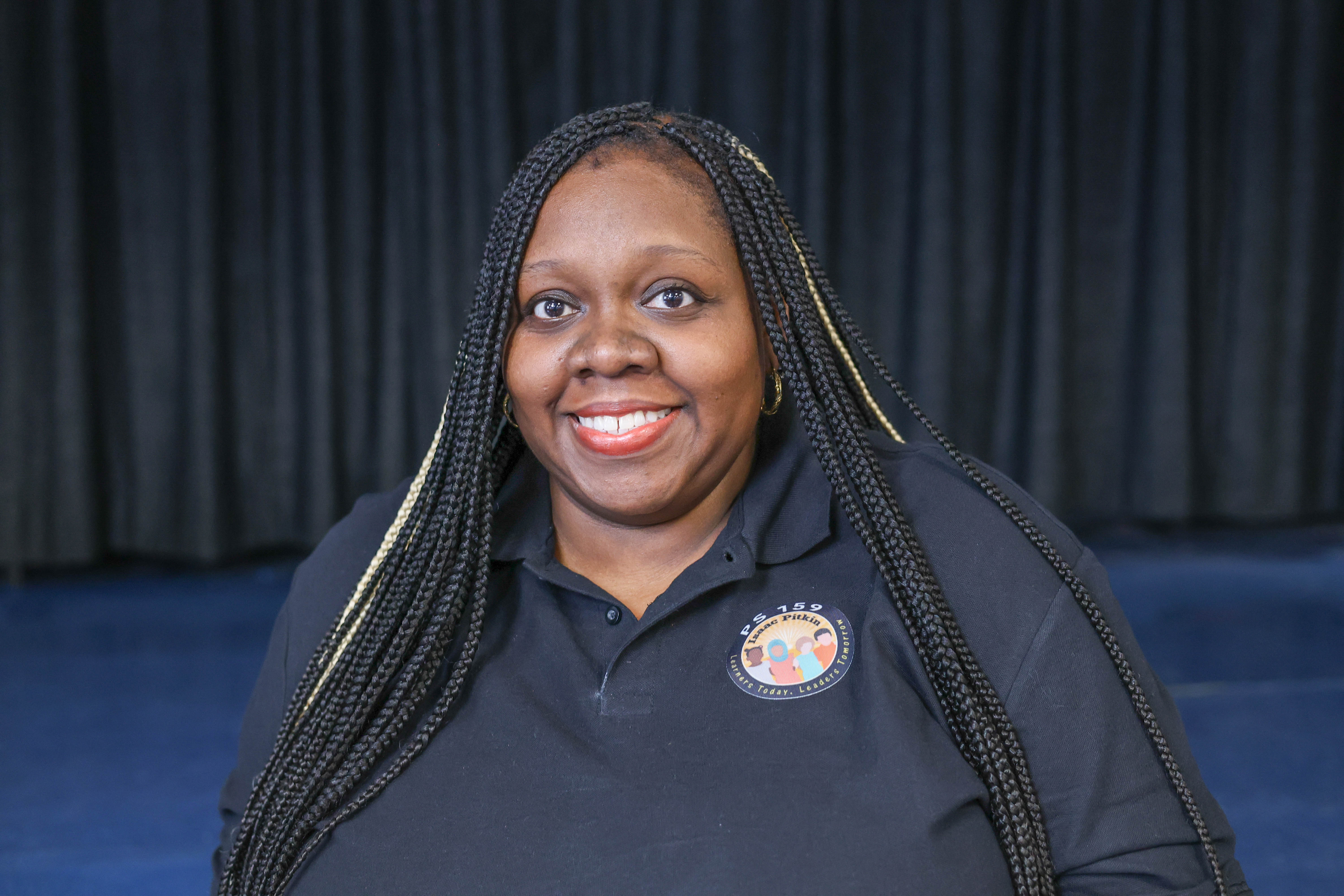 Carla Jennings PS 159 staff member smiling in school polo