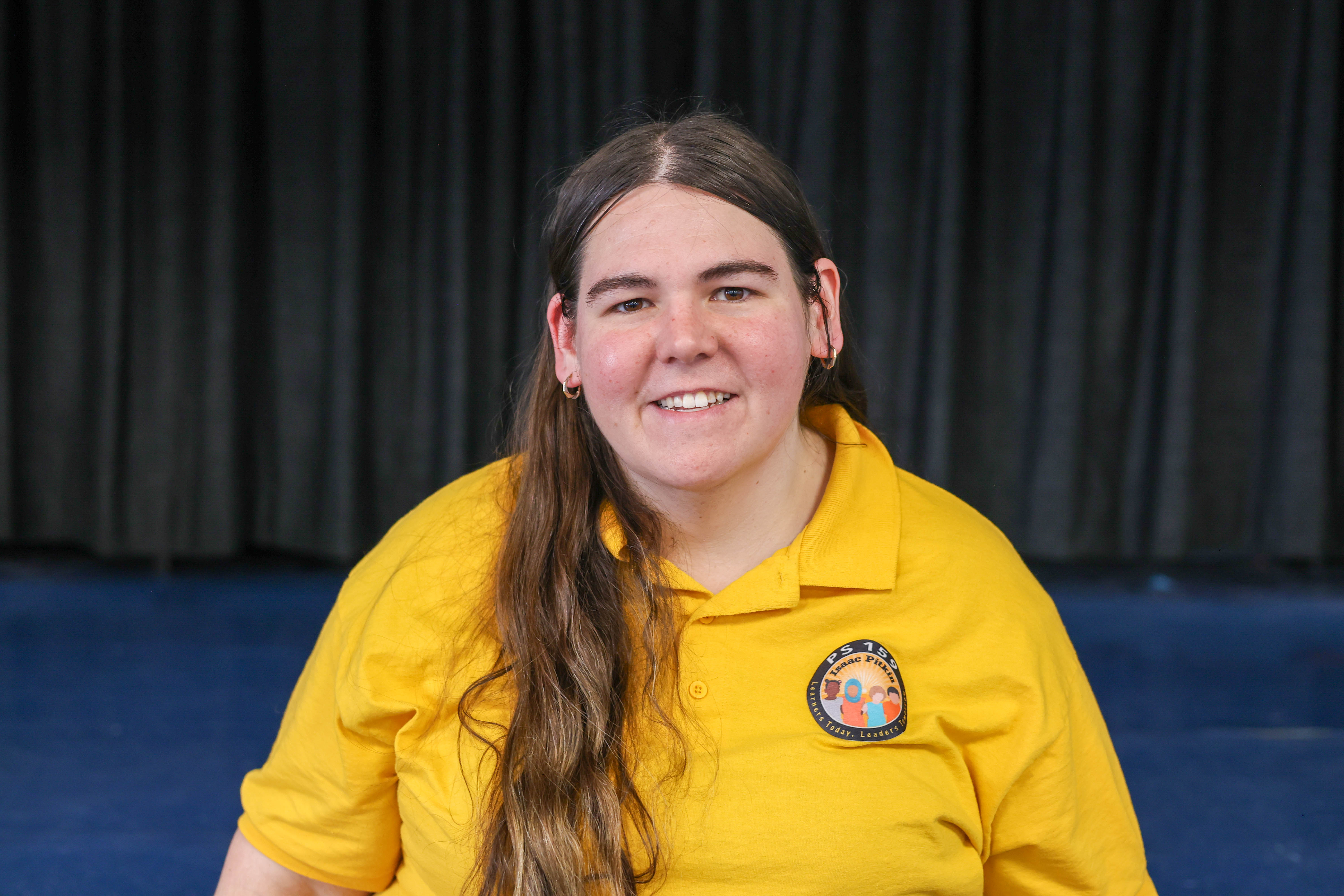 Samantha Policastro smiling in PS 159 yellow polo shirt