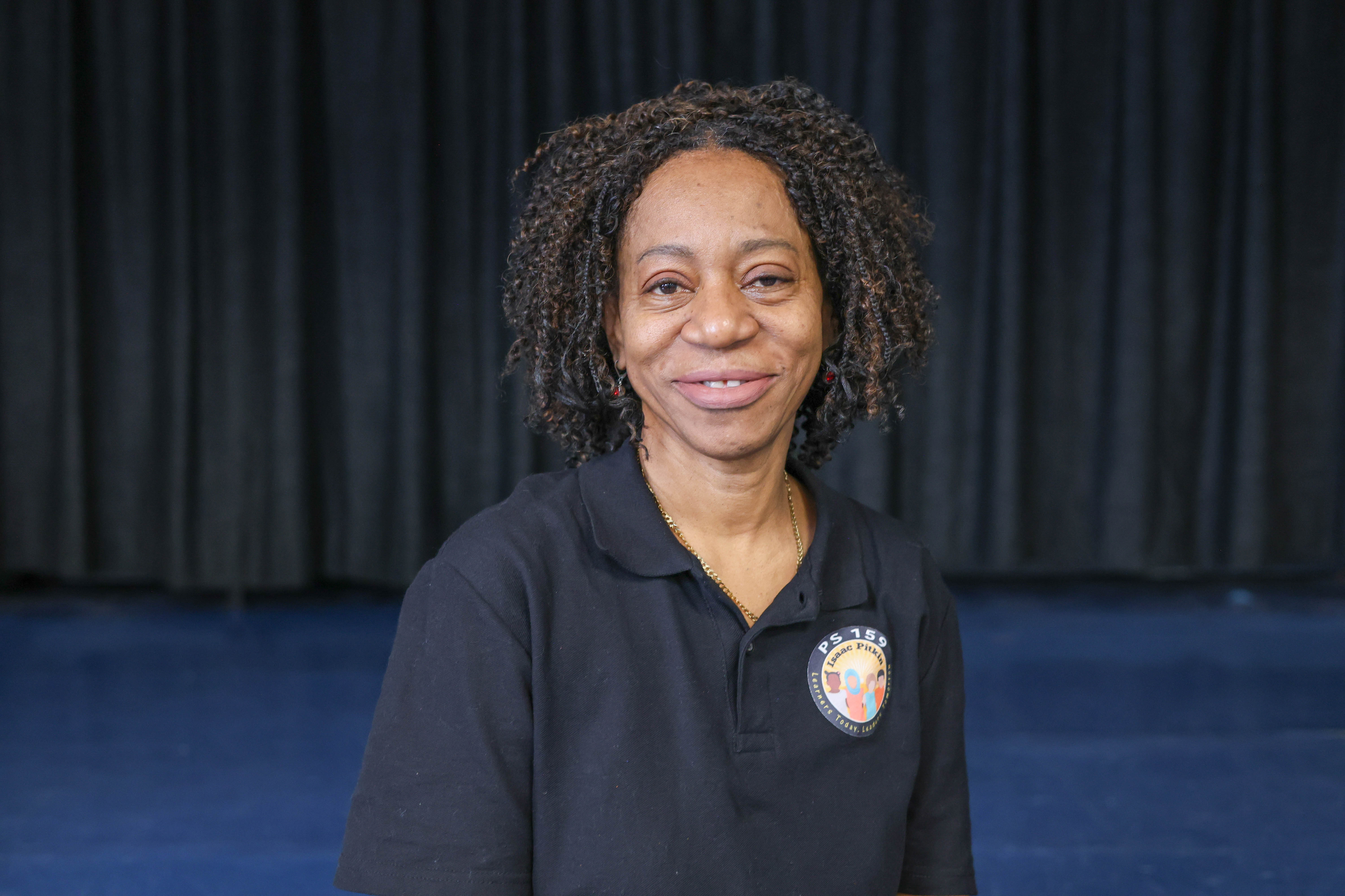 Dahlia Oliver-Johnson PS 159 staff member smiling in school polo