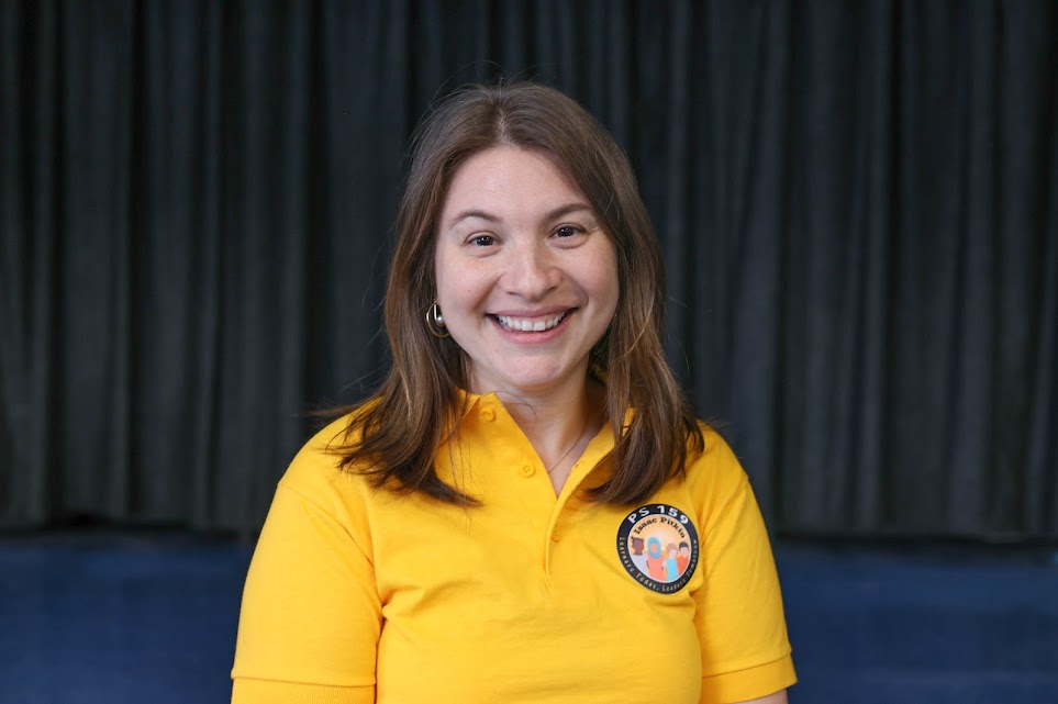 Staff member smiling in PS 159 yellow polo shirt