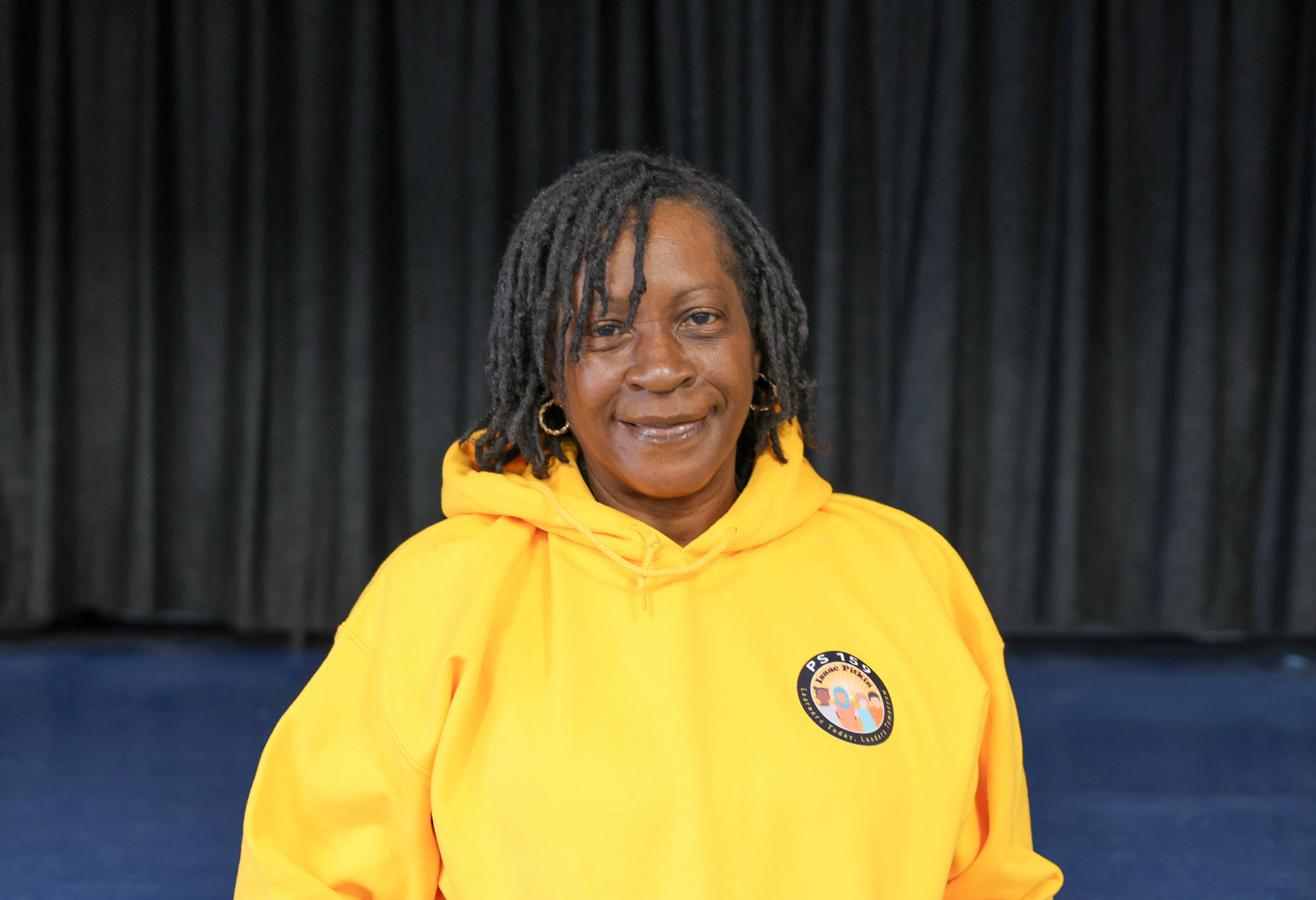 Arlecia Gordon smiling in a yellow PS 159 school hoodie