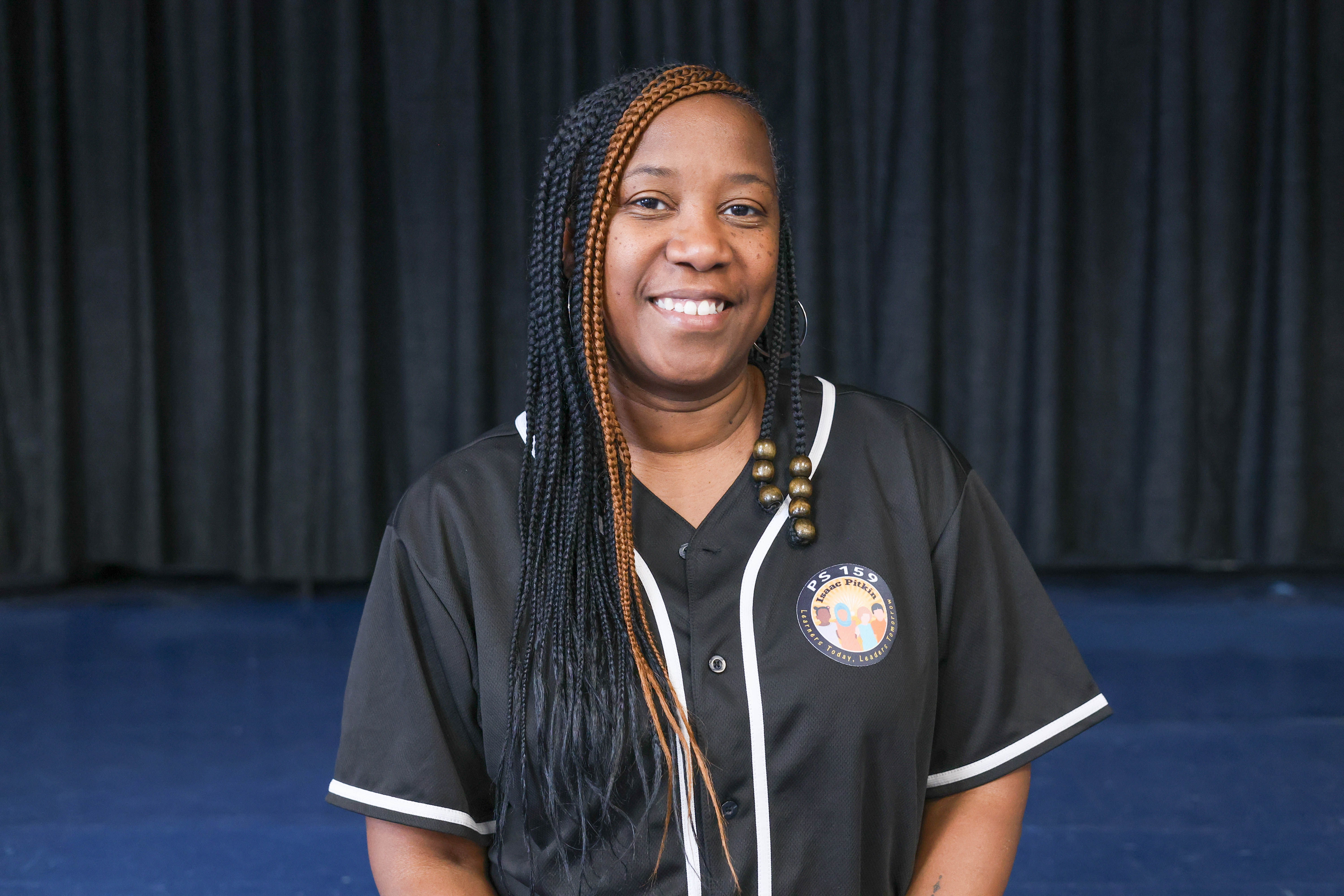 Staff member smiling in PS 159 school jersey