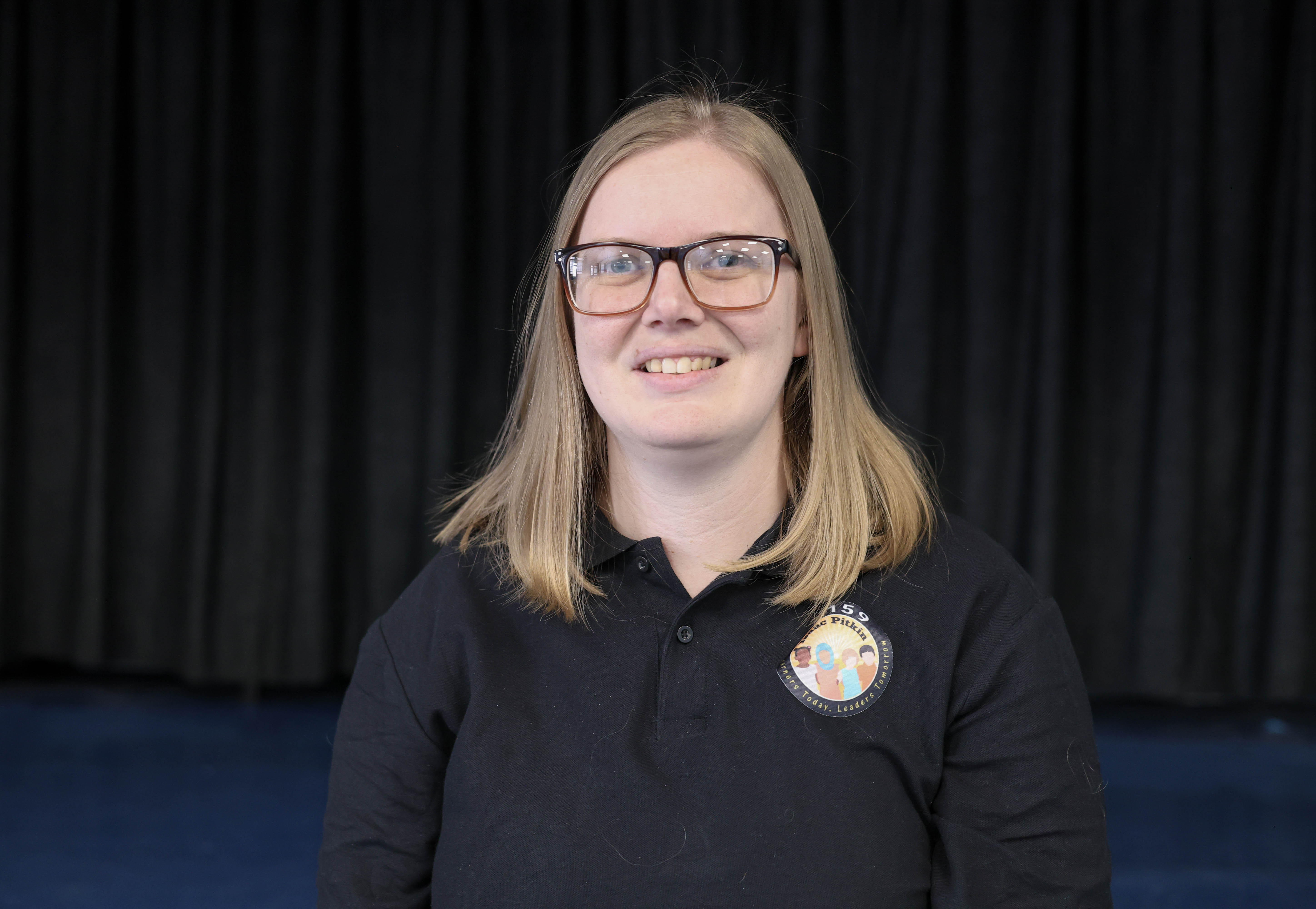 Staff member Elizabeth Wasek smiling in school polo shirt