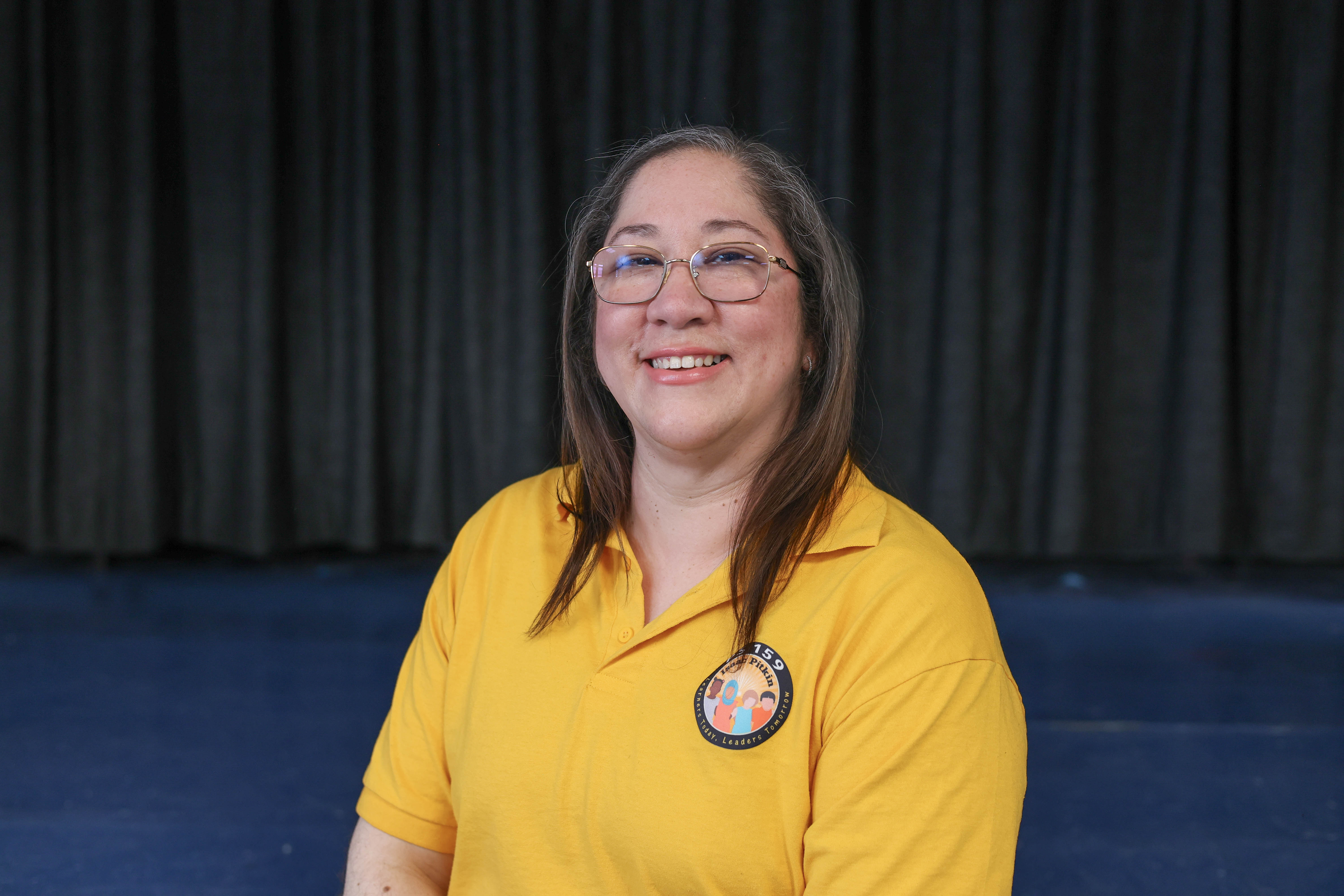 Niasia Cotto smiling in a yellow school polo shirt