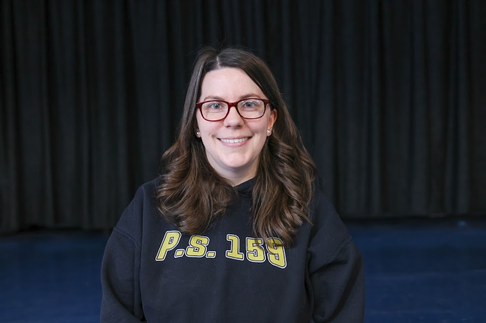 Kelly Paskor smiling in a PS 159 sweatshirt