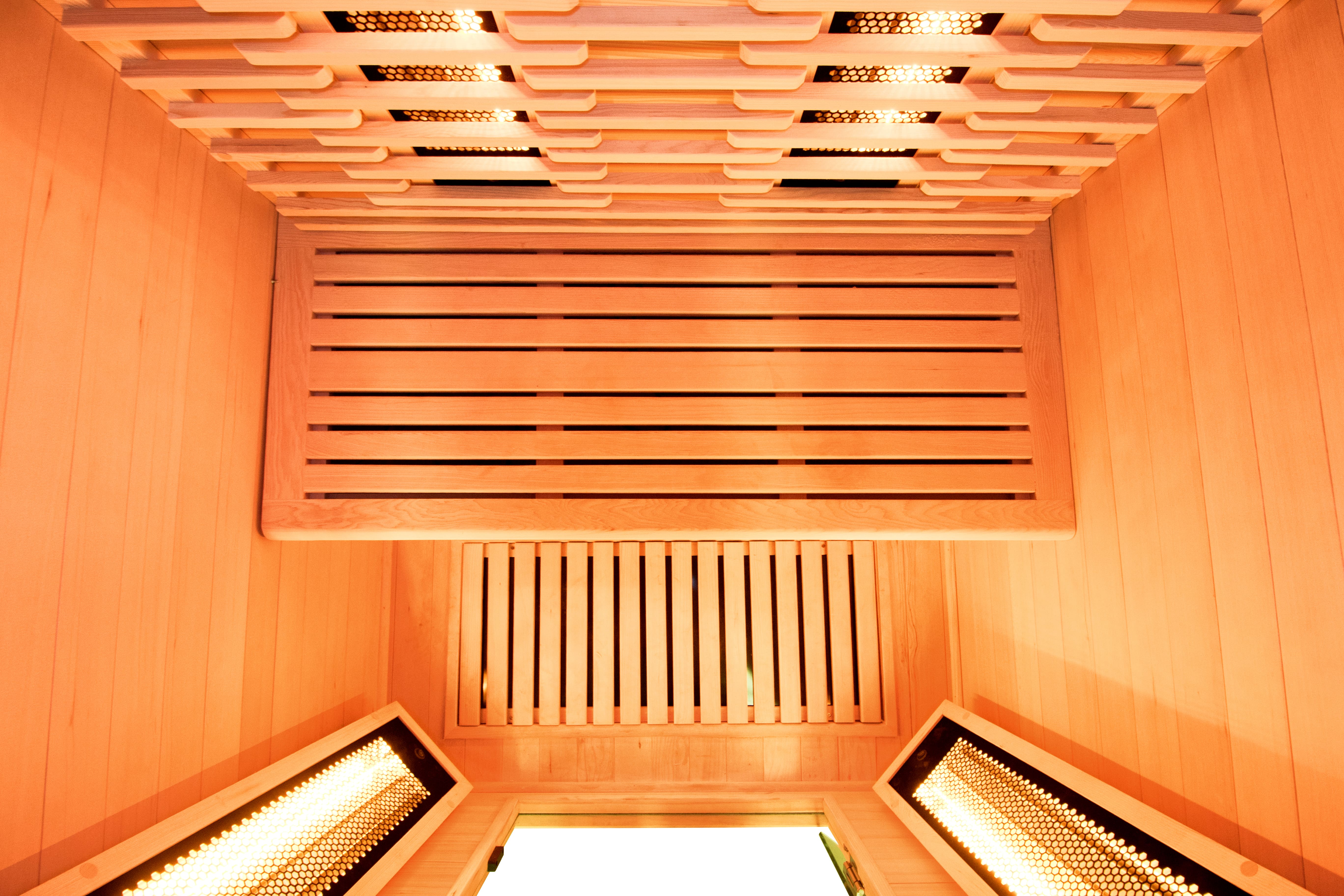 Intérieur d'un sauna infrarouge en bois avec ses émetteurs allumés