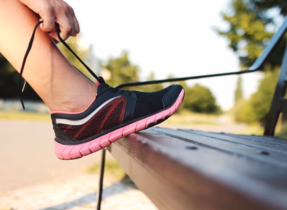 person tying shoelace on bench