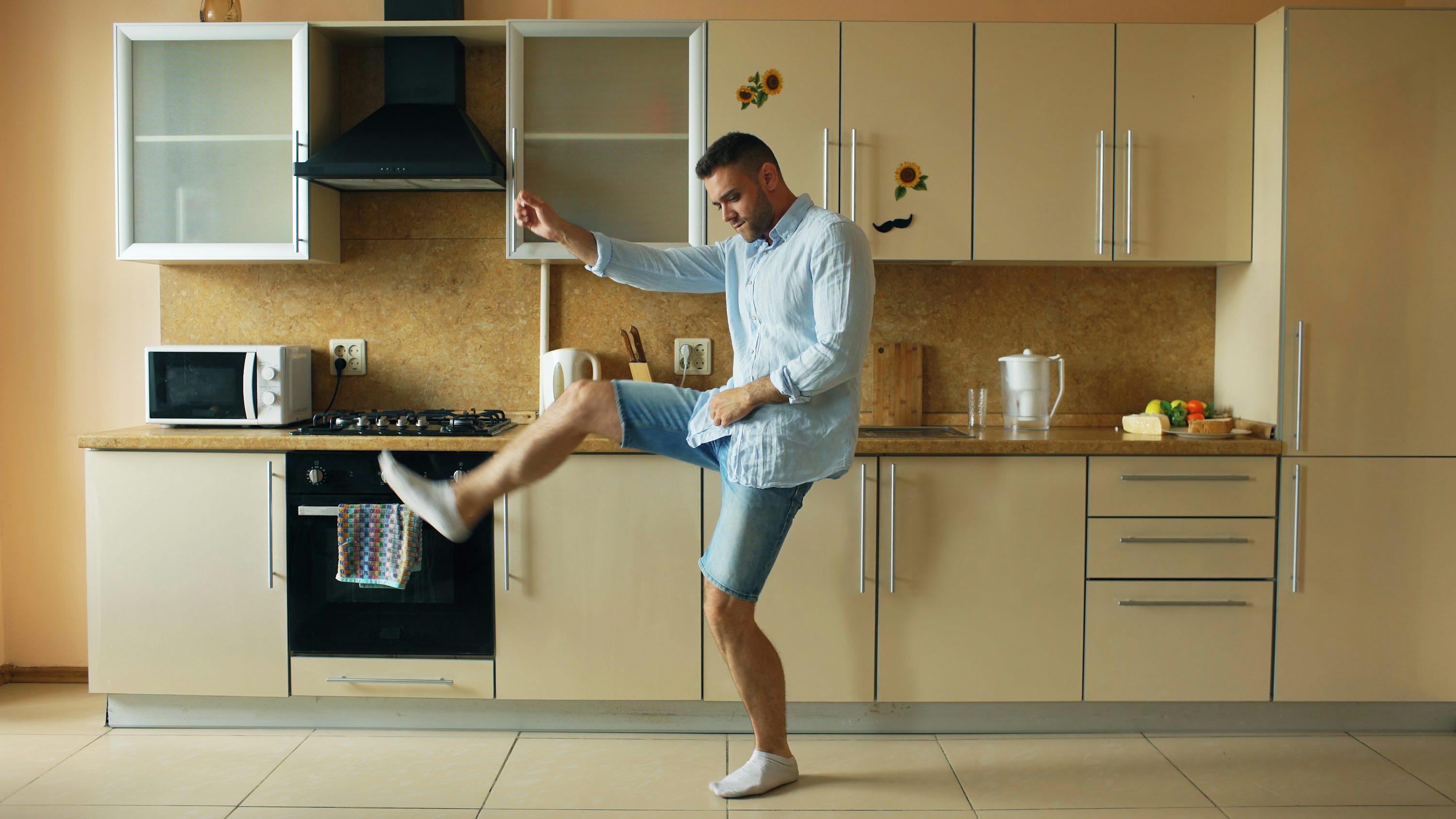 Man dancing energetically in a modern kitchen.